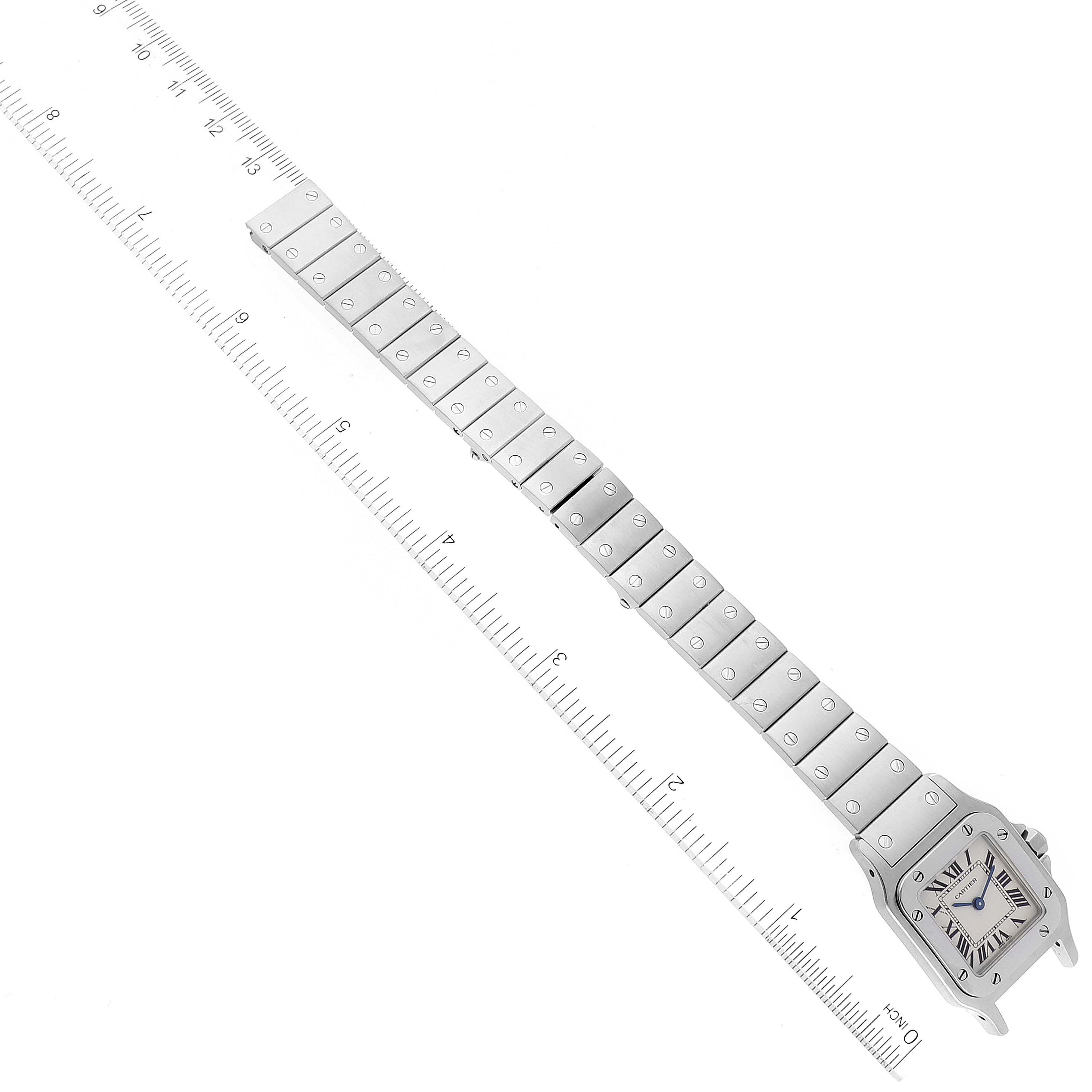 This image shows an overhead view of the Santos model watch by Cartier, including the face and full metal strap with a ruler for scale.