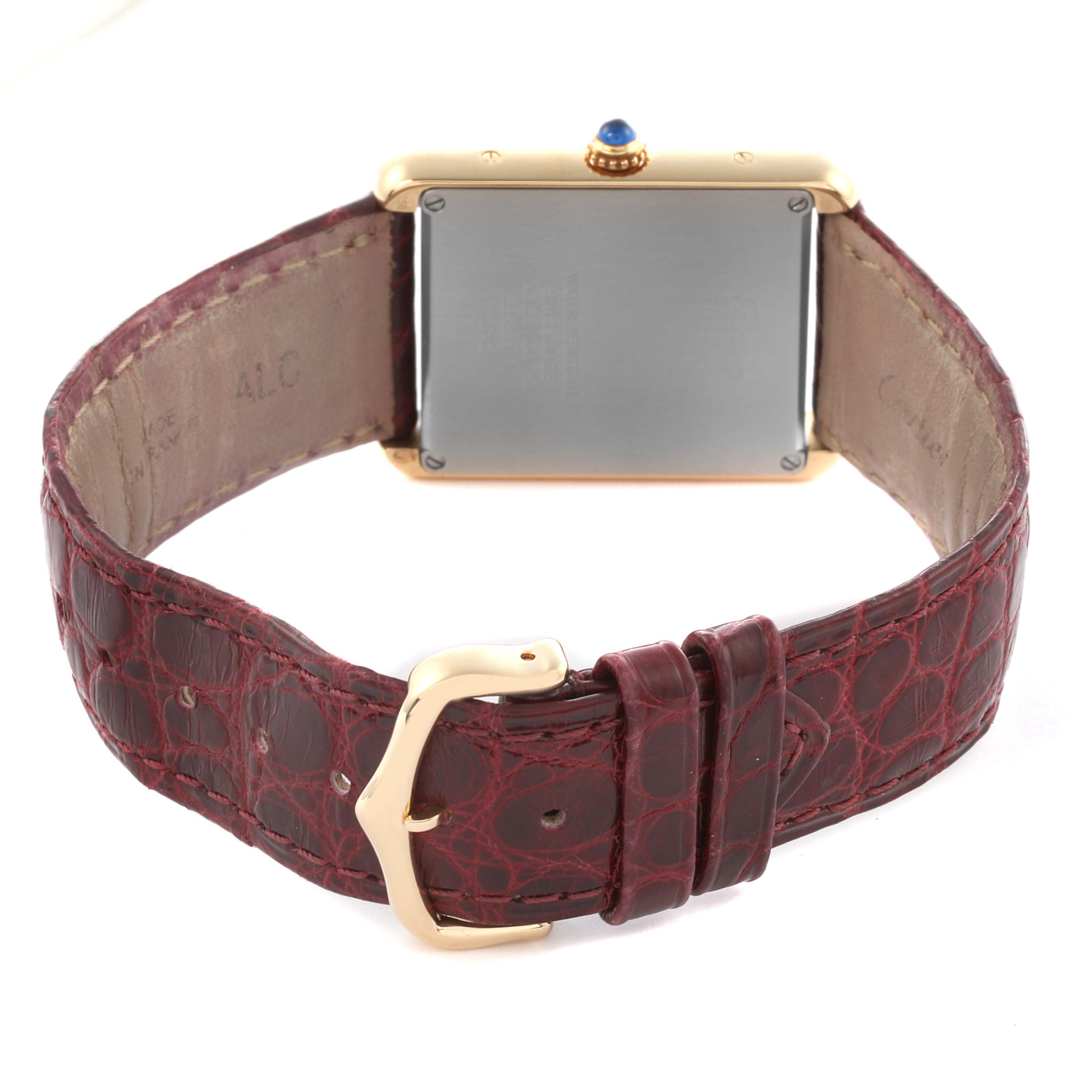 The image shows the back of a Cartier Tank Solo W1018855 Men's Steel and Gold (two tone) Silver Dial W1018855 Men's Steel and Gold (two tone) Silver Dial watch, highlighting the gold case, crown, and brown leather strap with a buckle.