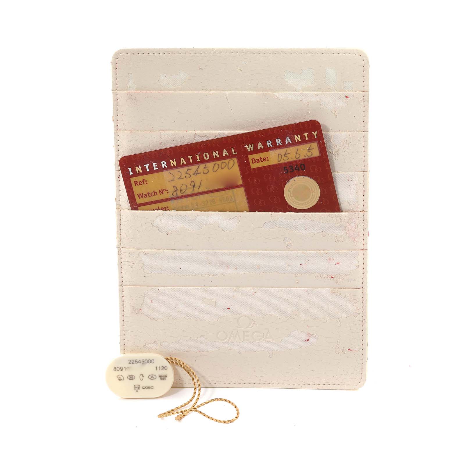 The image shows an Omega Seamaster 2254.50.00 Men
s Stainless Steel Black Dial 2254.50.00 Men
s Stainless Steel Black Dial International Warranty card and a tag, placed inside a cream-colored cardholder.