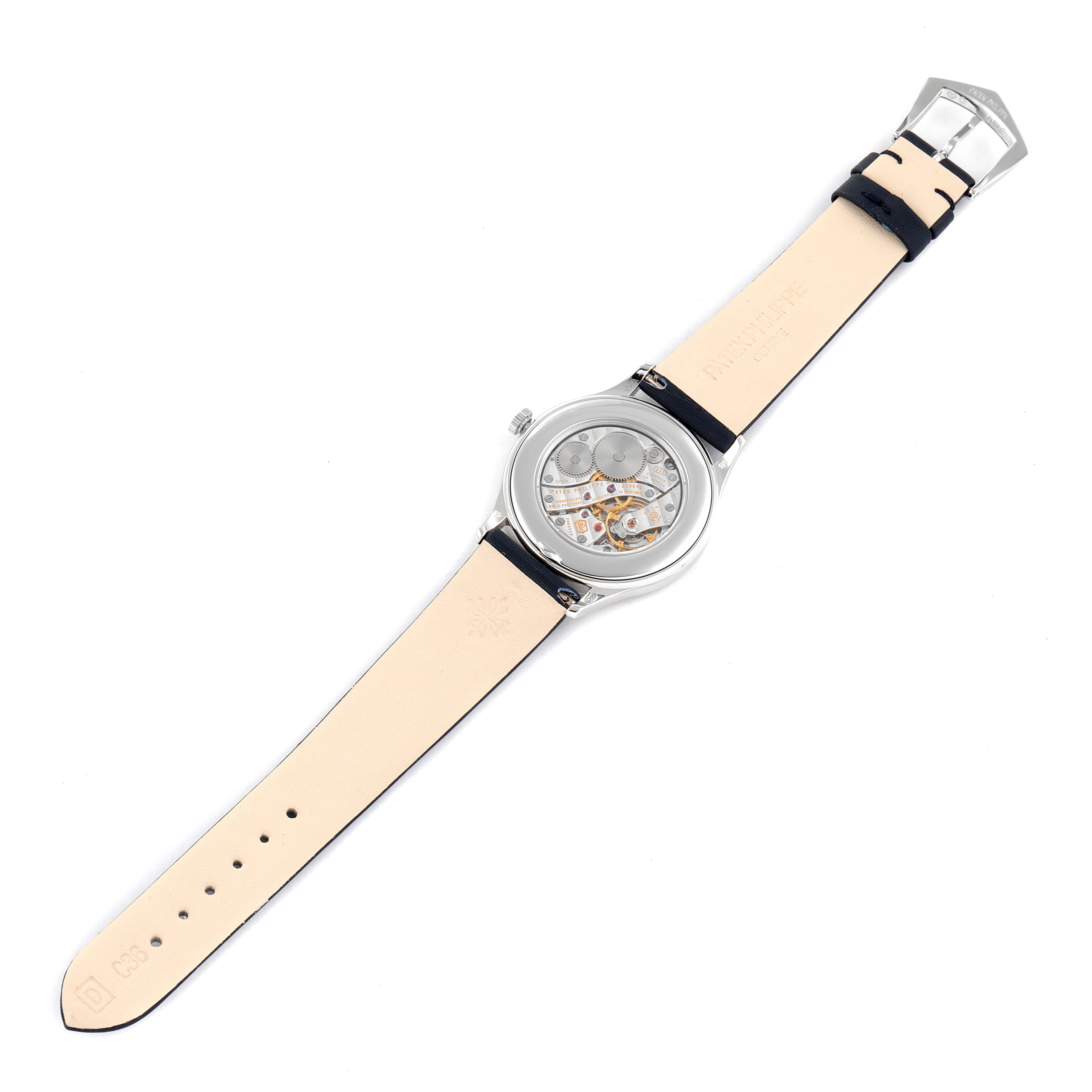 The image shows the back of a Patek Philippe Calatrava 4897G-001 Women's White Gold Blue Dial 4897G-001 Women's White Gold Blue Dial watch, displaying the mechanical movement and leather strap.