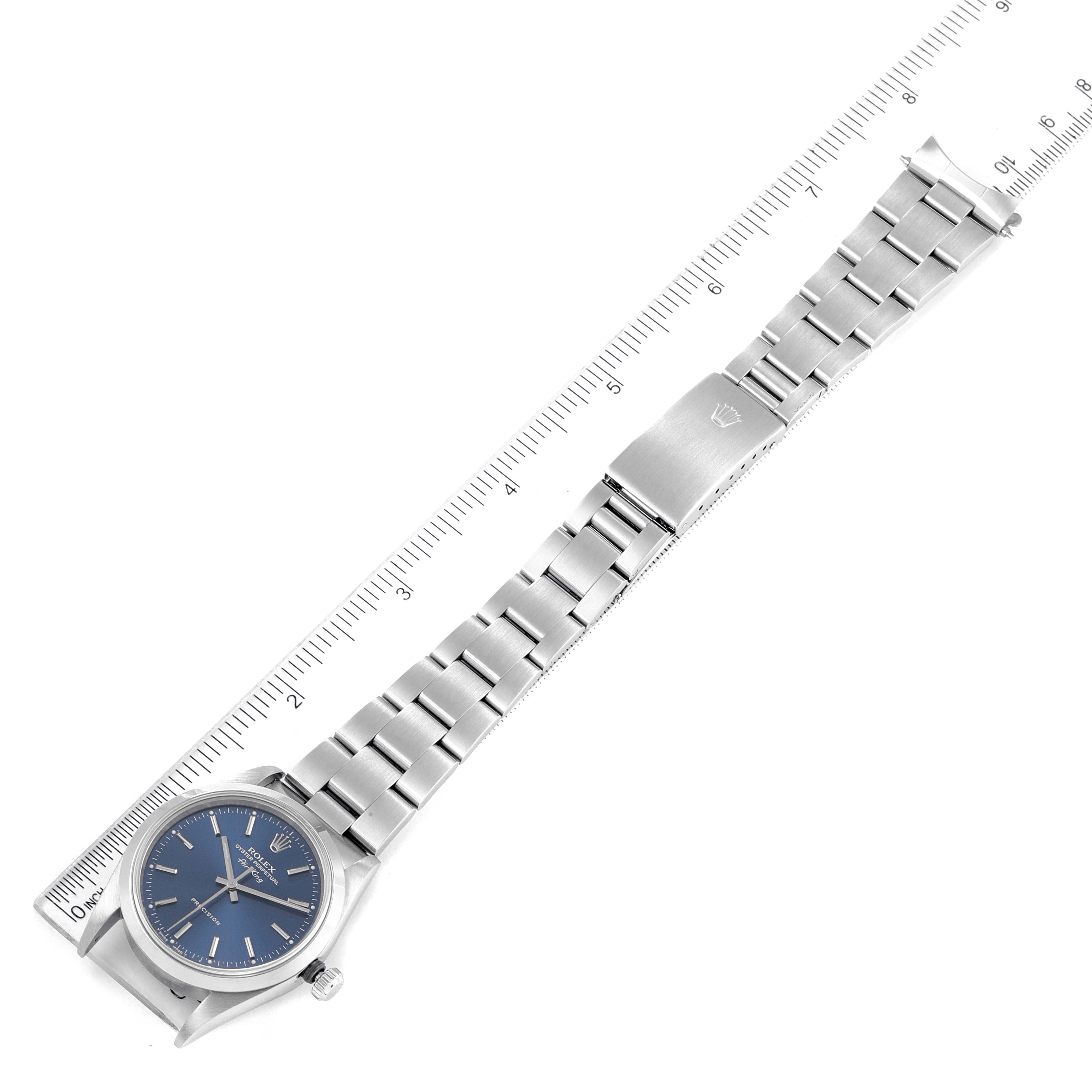 The image shows a top view of a Rolex Air-King 14000 Men's Stainless Steel Blue Dial 14000 Men's Stainless Steel Blue Dial watch with its face, bezel, crown, and full metal bracelet laid out next to a ruler.