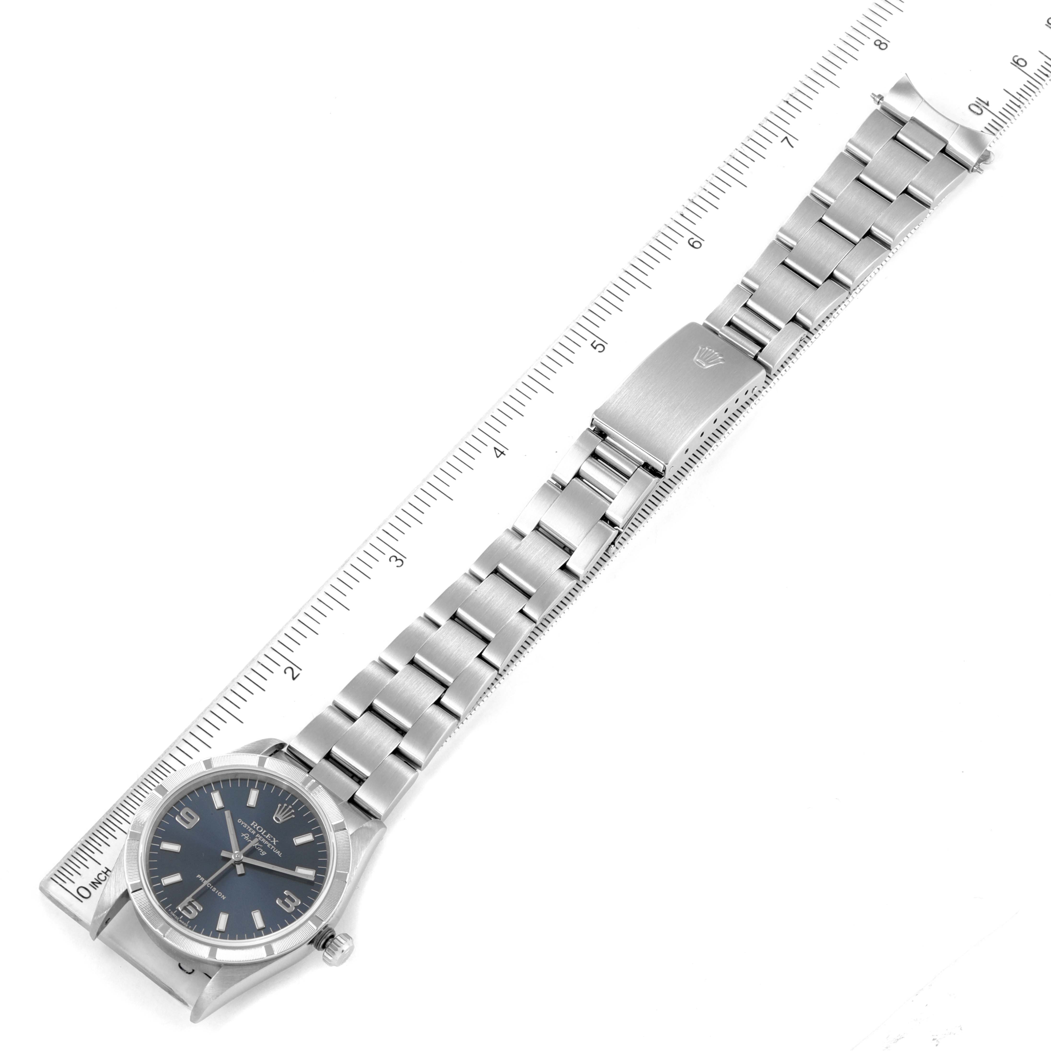 The image shows an overhead view of a Rolex Air-King 14010 Men's Stainless Steel Blue Dial 14010 Men's Stainless Steel Blue Dial watch with a metal bracelet next to a ruler for scale.