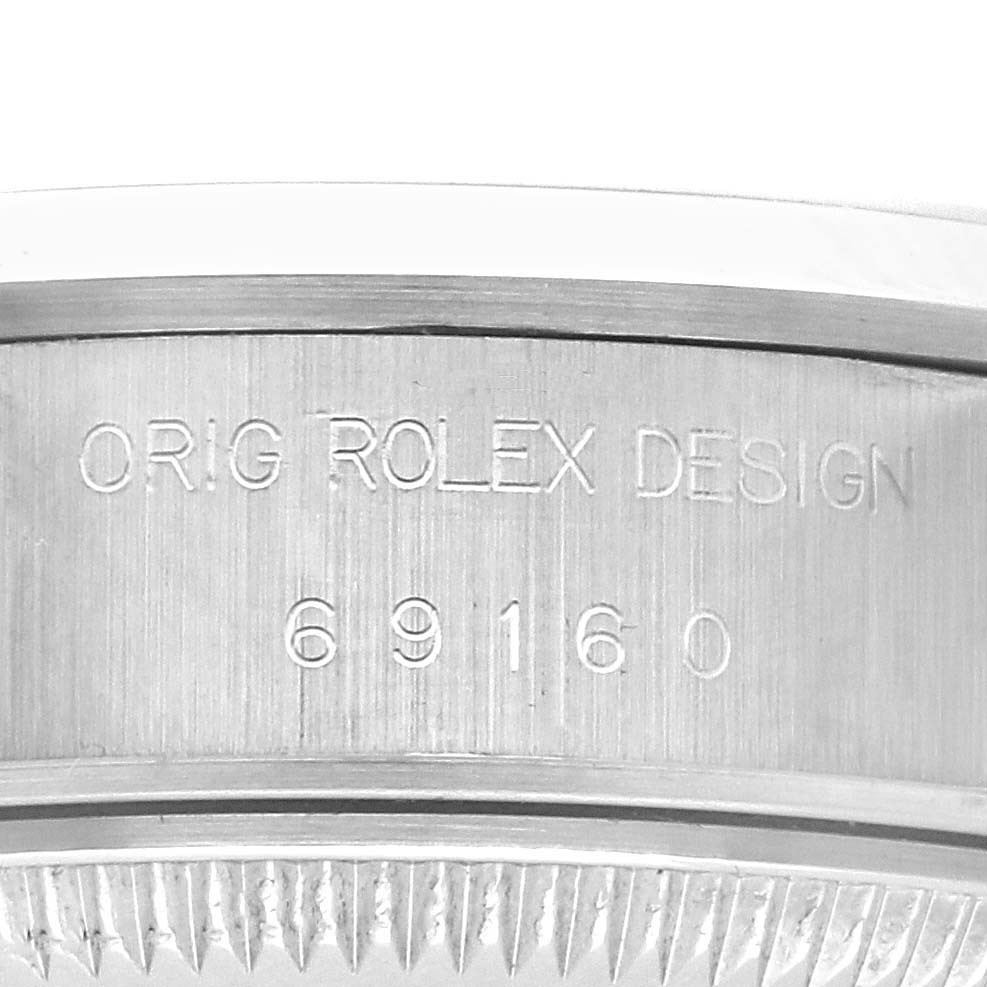 The image shows a close-up of the case side of a Rolex Date 69160 Women's Stainless Steel Blue Dial 69160 Women's Stainless Steel Blue Dial model with engraving details.