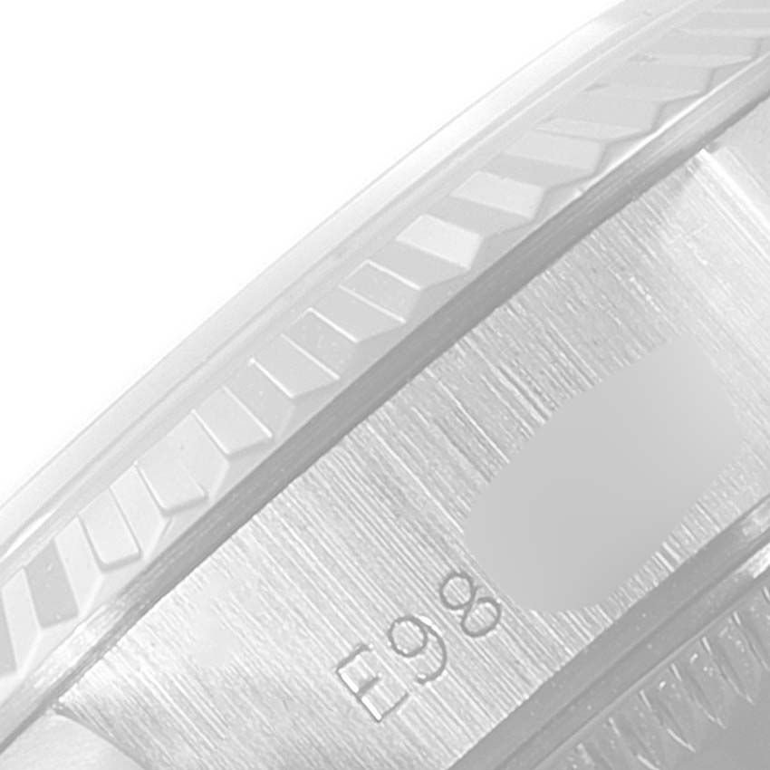 The image shows a close-up of the side of a Rolex Datejust 69174 Women's Stainless Steel Black Dial 69174 Women's Stainless Steel Black Dial watch case, highlighting its texture and engravings.