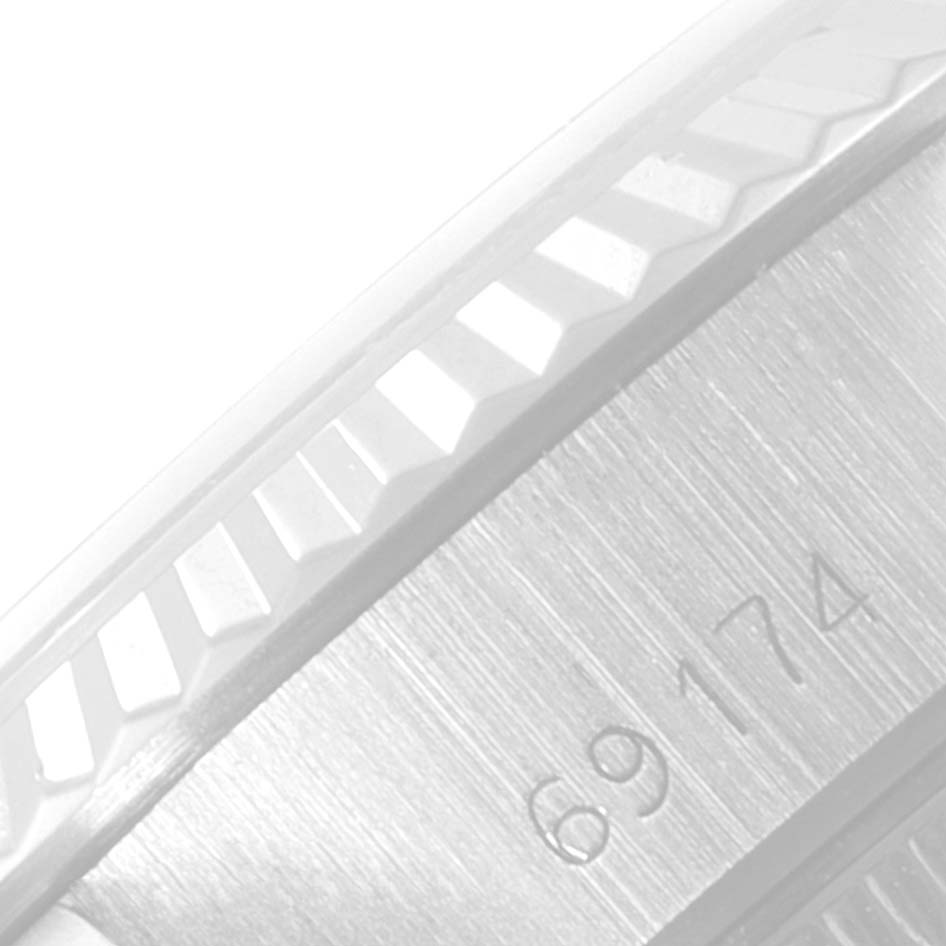 This close-up image of the Rolex Datejust 69174 Women's Stainless Steel Black Dial 69174 Women's Stainless Steel Black Dial watch shows a partial view of the bezel and case with the model number "69174" engraved.