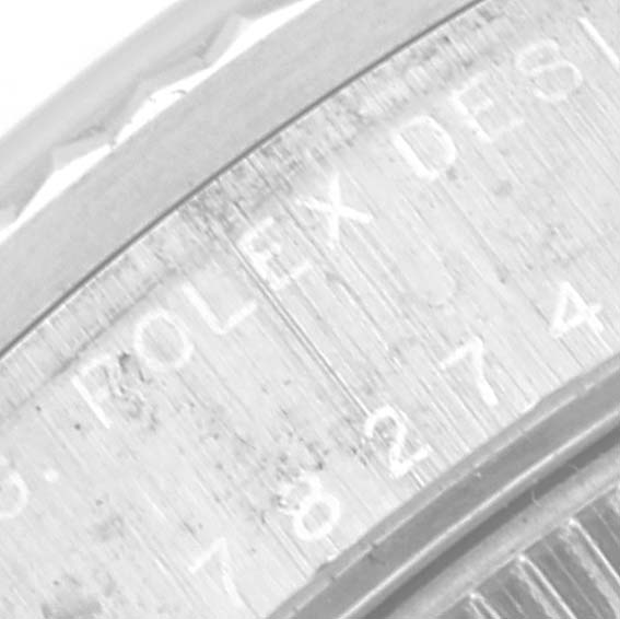 This close-up image shows the side engraving on the bezel of a Mid-Size Rolex watch, displaying its model and serial number.