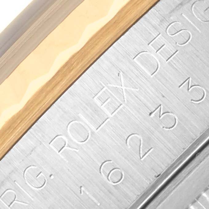 The image shows a close-up of the case side of a Rolex Datejust 16233 Men's Steel and Gold (two tone) Black Dial 16233 Men's Steel and Gold (two tone) Black Dial, highlighting engraved text on the metal.