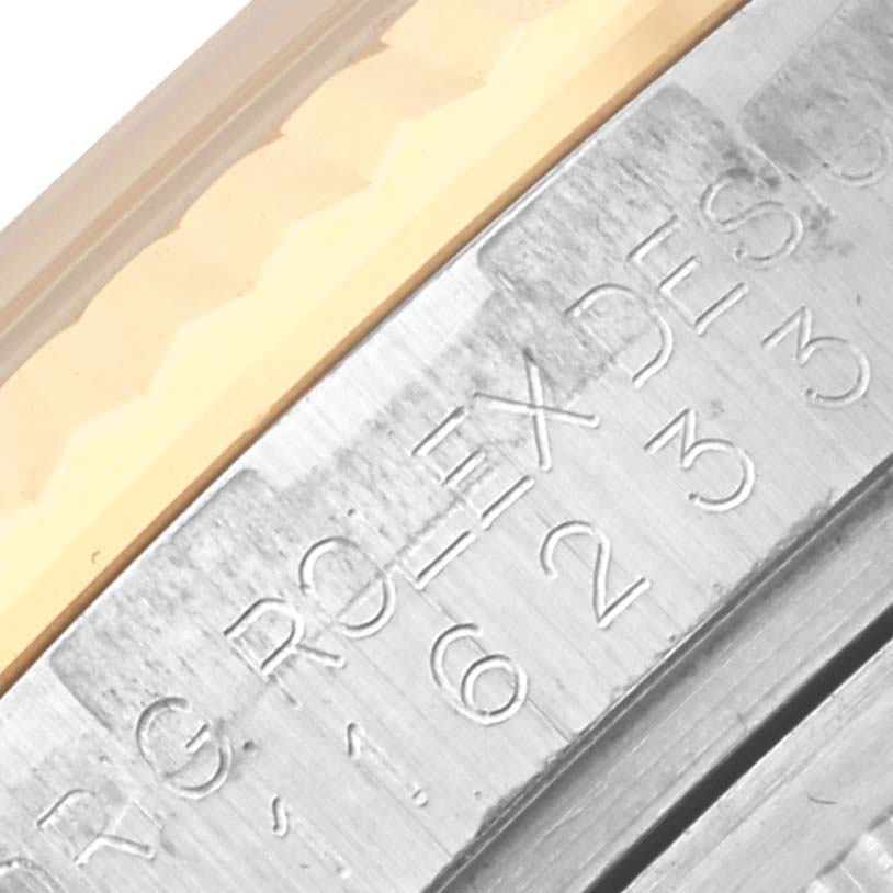 The image shows a close-up angle of the Rolex Datejust 116233 Men's Steel and Gold (two tone) Silver Dial 116233 Men's Steel and Gold (two tone) Silver Dial's engraved bezel edge.