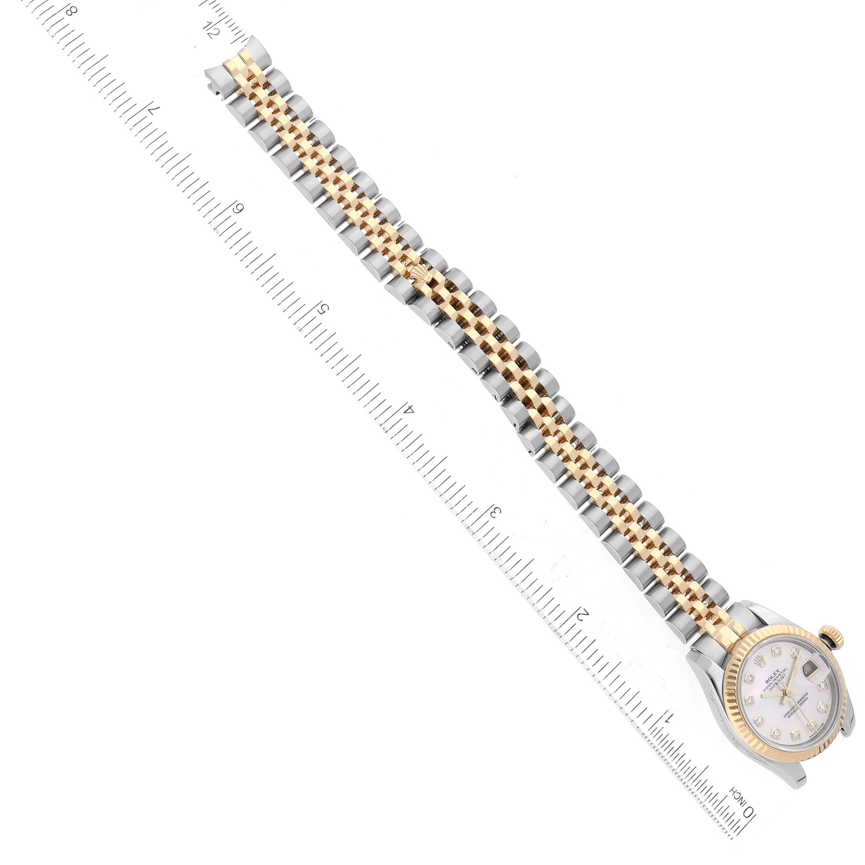 This image shows a Rolex Datejust 179173 Women's Steel and Gold (two tone) Mother of Pearl Dial 179173 Women's Steel and Gold (two tone) Mother of Pearl Dial watch from a top view, displaying its dial and two-tone bracelet alongside a ruler for scale.