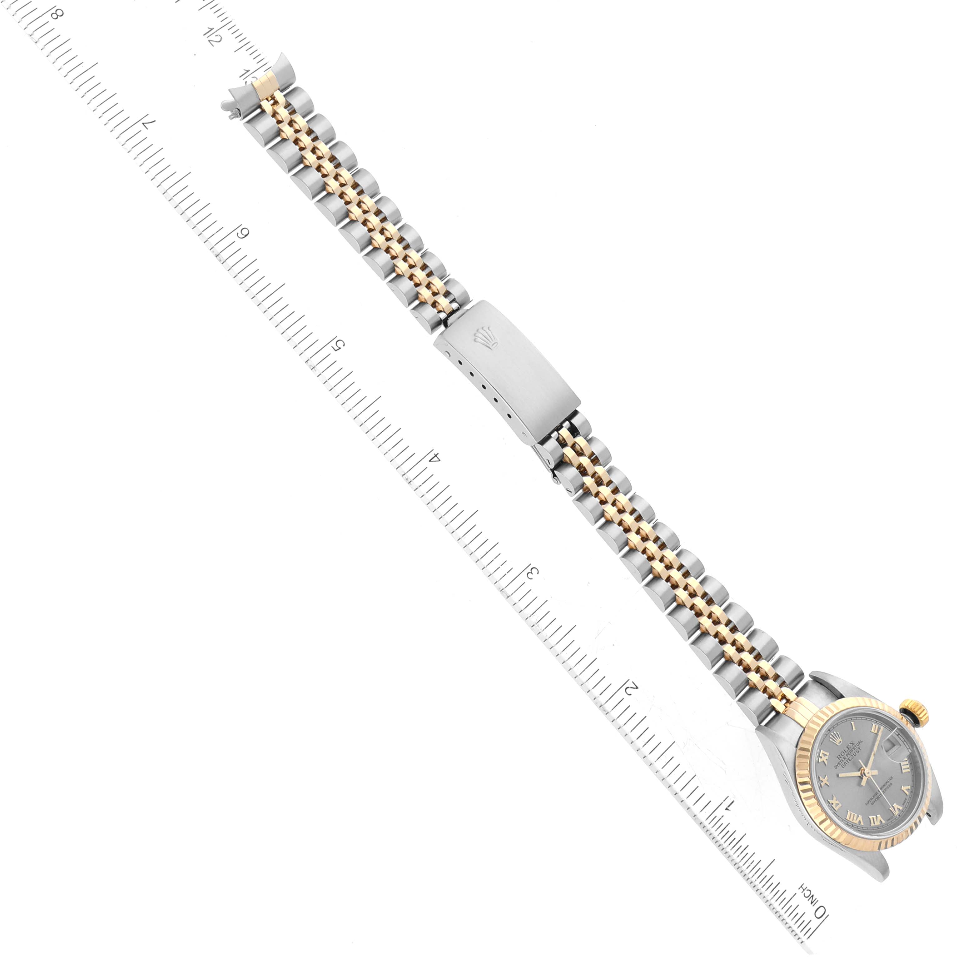 The image shows a full view of a Rolex Datejust 79173 Women's Steel and Gold (two tone) Grey Dial 79173 Women's Steel and Gold (two tone) Grey Dial watch laid out flat, including the dial, bracelet, and clasp against a ruler.
