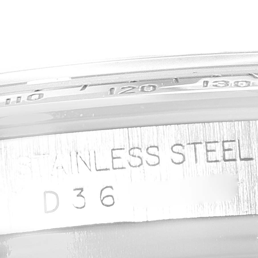 This close-up image of a Rolex Daytona 116520 Men's Stainless Steel Black Dial 116520 Men's Stainless Steel Black Dial watch shows the edge of the bezel and the "Stainless Steel" engraving on the case.