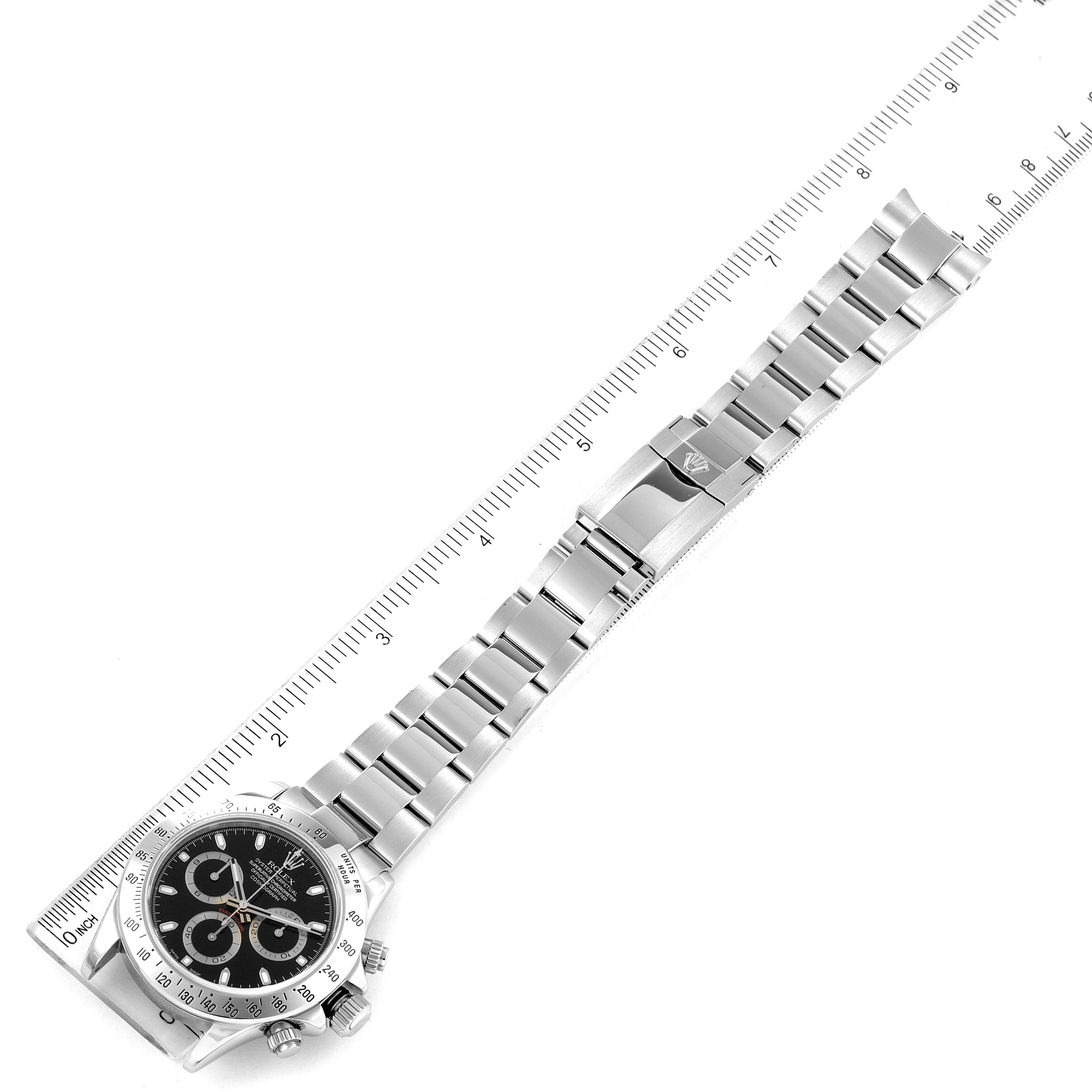The image shows a top-down view of the Rolex Daytona 116520 Men's Stainless Steel Black Dial 116520 Men's Stainless Steel Black Dial watch, focusing on its stainless steel bracelet and clasp, alongside a ruler.