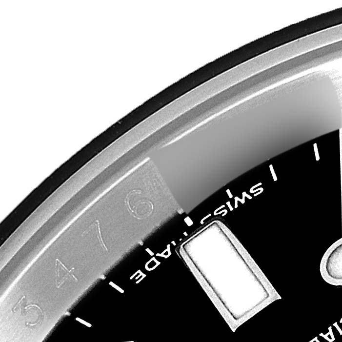 This image shows a close-up of the dial and edge of the bezel of a Rolex GMT-Master 116710 Men's Stainless Steel Black Dial 116710 Men's Stainless Steel Black Dial watch.