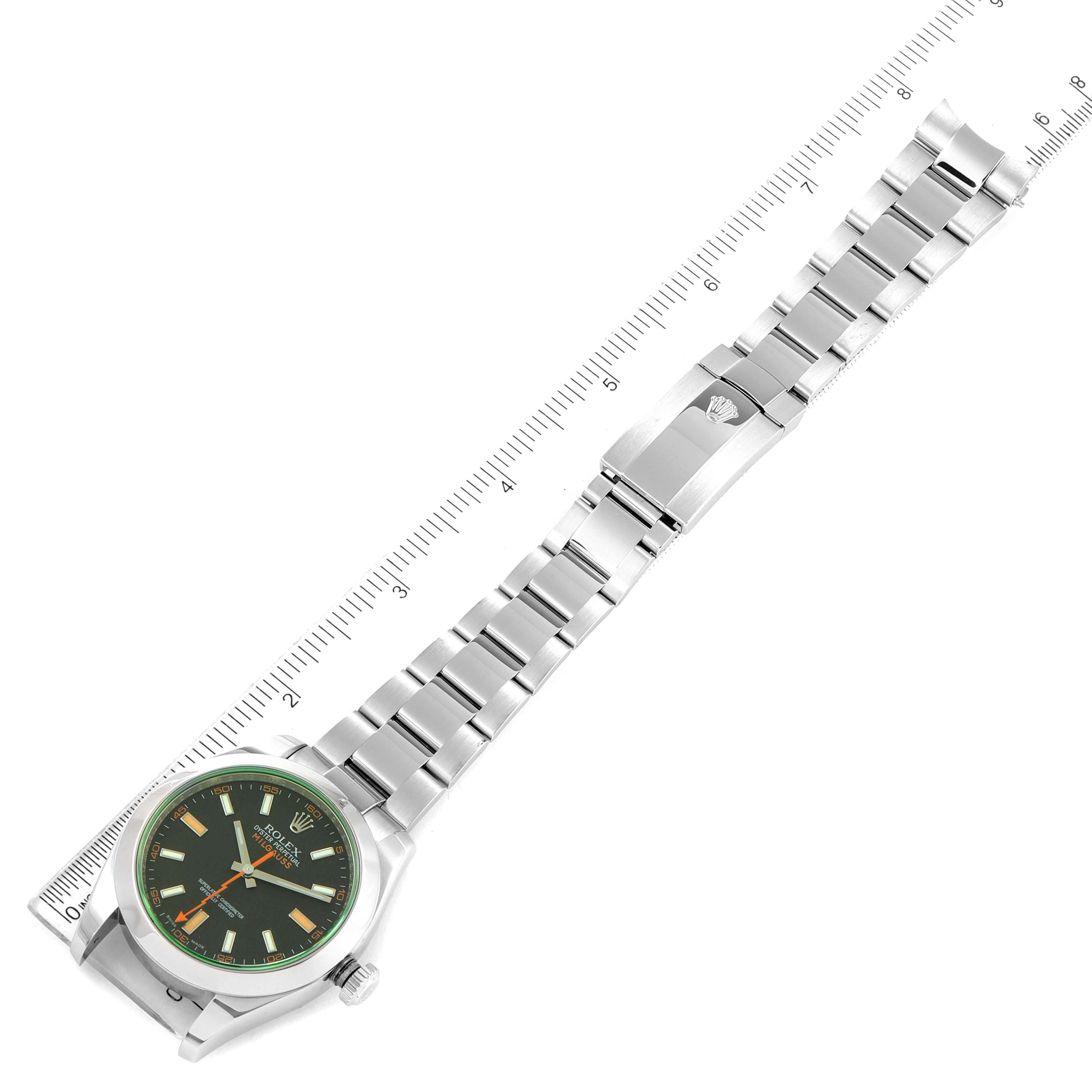The image shows a Rolex Milgauss 116400V Men's Stainless Steel Black Dial 116400V Men's Stainless Steel Black Dial watch from a top-down angle with its face, bracelet, and clasp visible, alongside a ruler for scale.