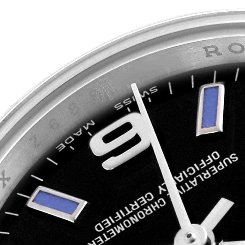 The image shows a close-up of the dial and bezel of the Rolex Oyster Perpetual 176200 Women's Stainless Steel Black Dial 176200 Women's Stainless Steel Black Dial, highlighting the 9 o'clock marker and text.