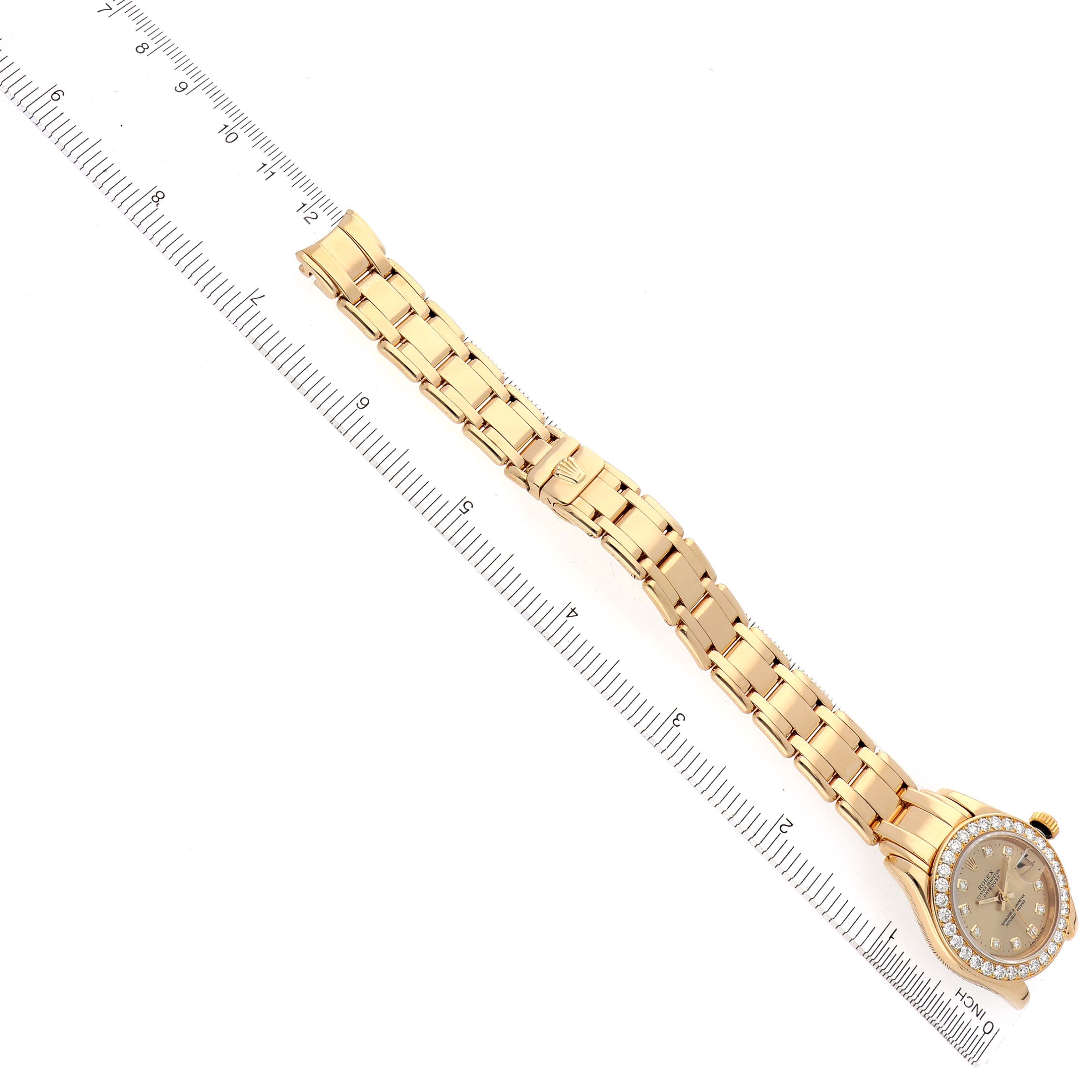 The Rolex Pearlmaster 69298 Women's Yellow Gold Champagne Dial 69298 Women's Yellow Gold Champagne Dial watch is shown from an angled top view, displaying the full bracelet and dial with a measuring ruler alongside.