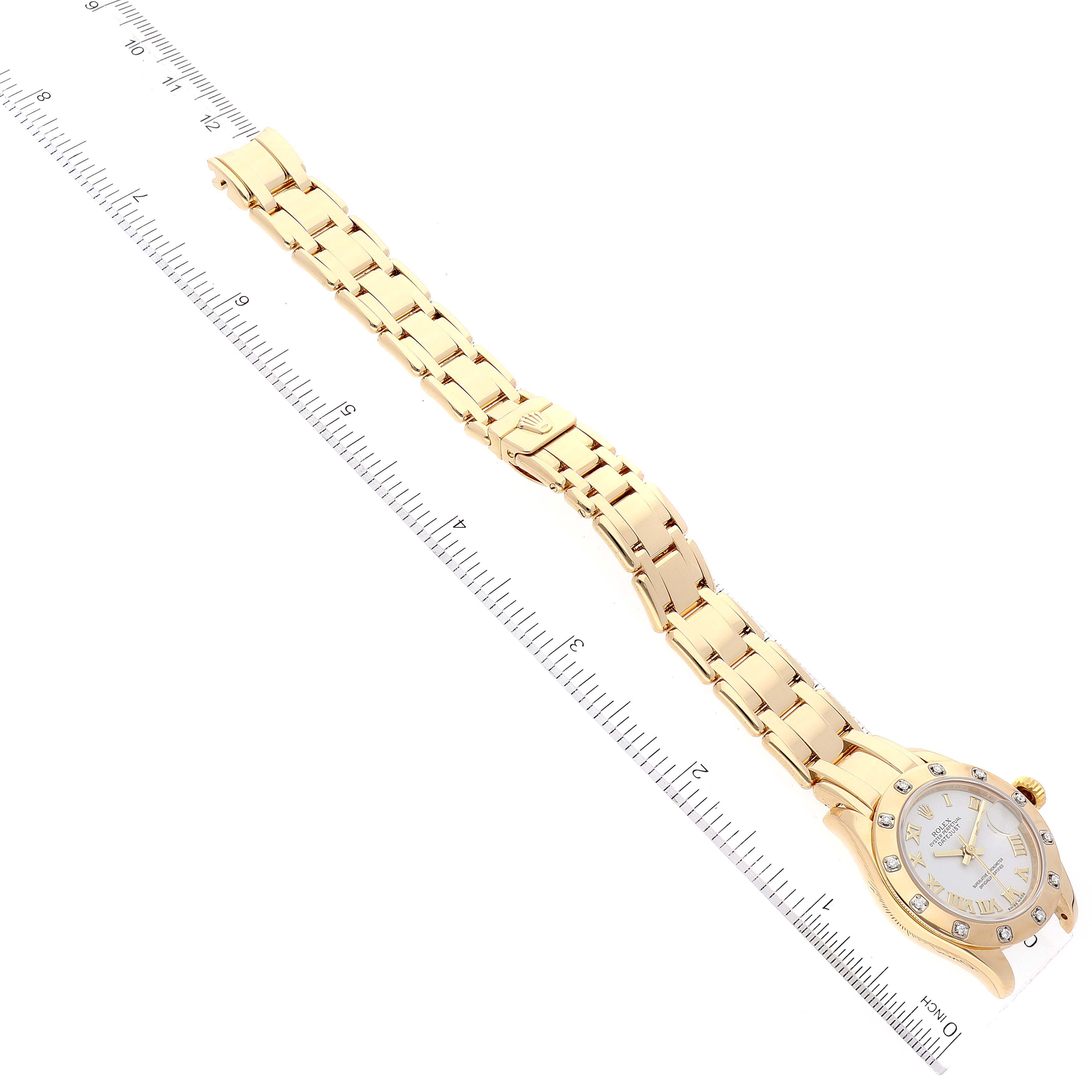 The Rolex Pearlmaster 80318 Women's Yellow Gold White Dial 80318 Women's Yellow Gold White Dial watch is shown laid flat, with its gold bracelet and face visible, against a ruler for scale.