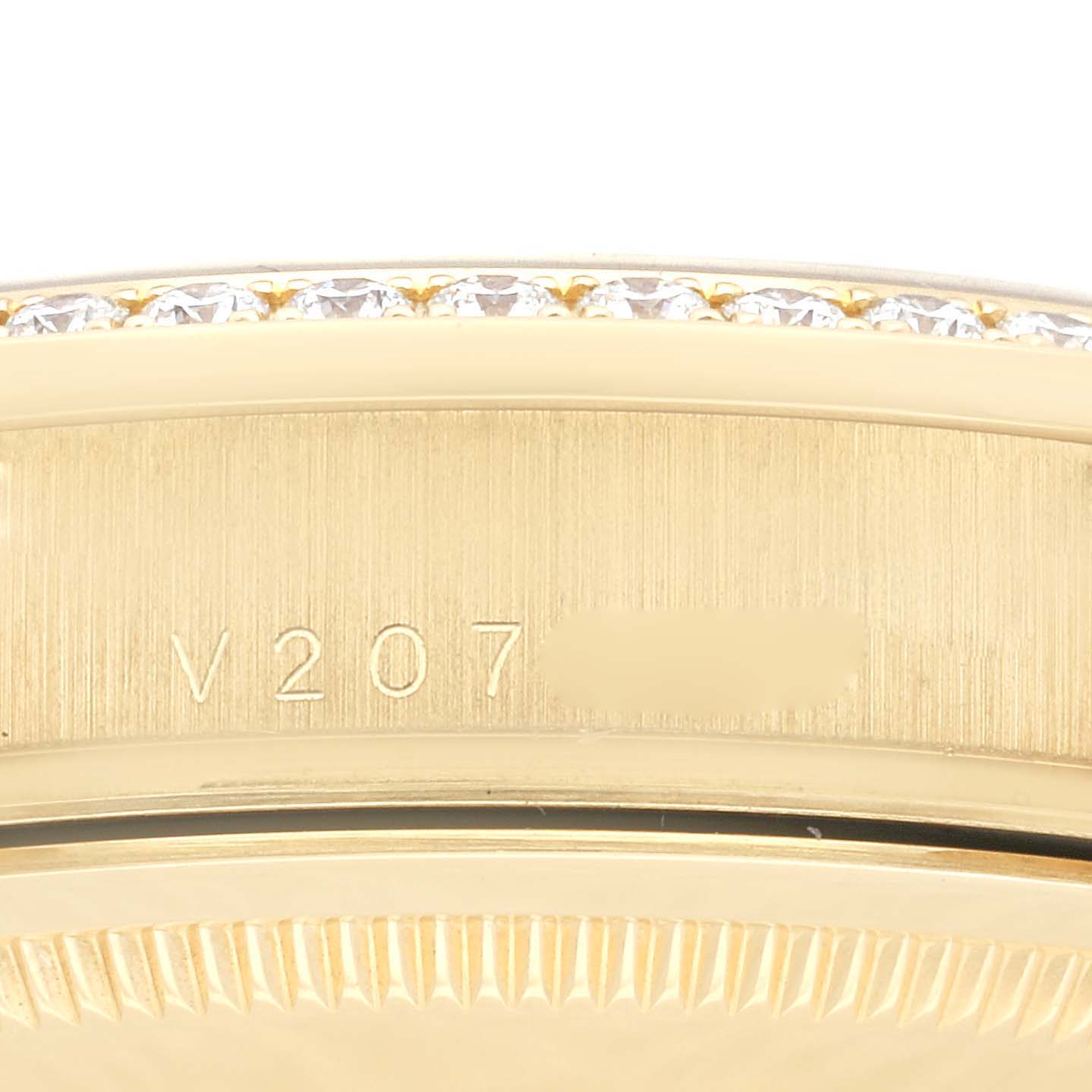 This close-up image shows the bezel with diamonds and part of the case with a serial number of the Rolex President 118388 Men
s Yellow Gold Champagne Dial 118388 Men
s Yellow Gold Champagne Dial model watch.