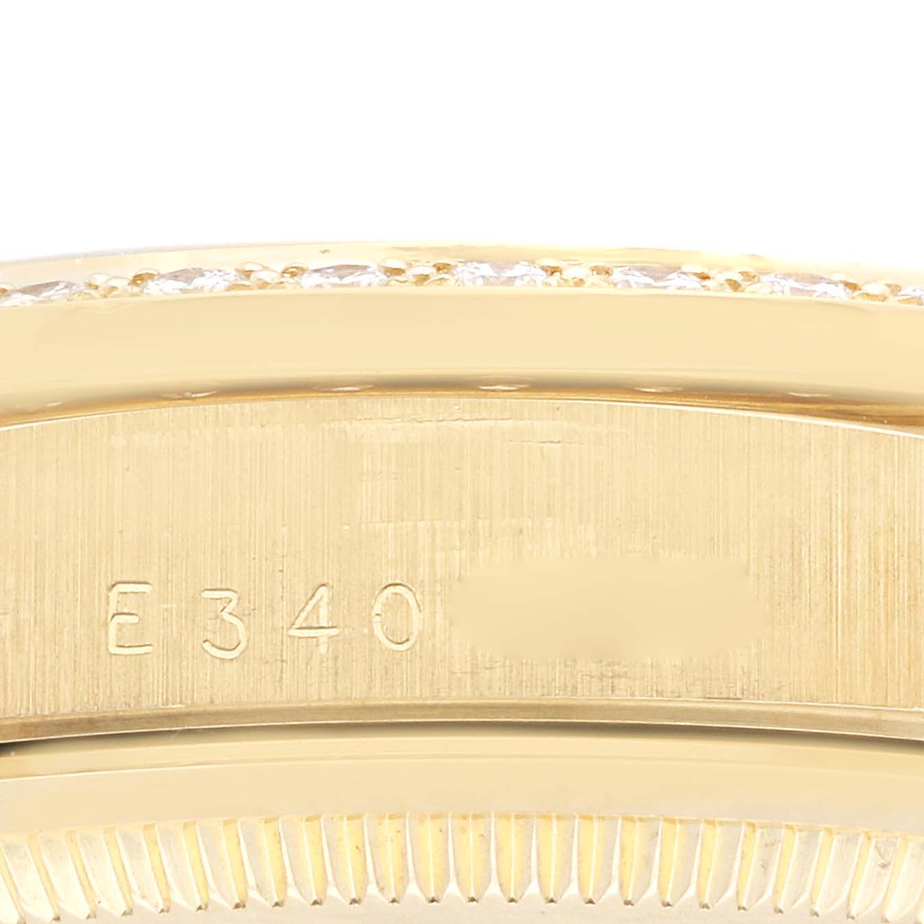 This close-up image shows the serial number engraving on the side of a Rolex President 18348 Men's Yellow Gold Champagne Dial 18348 Men's Yellow Gold Champagne Dial model watch.