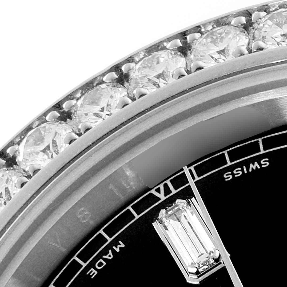 The image shows a close-up of the bezel and part of the dial of a Rolex President 218349 Men's White Gold Black Dial 218349 Men's White Gold Black Dial model watch, highlighting its diamond accents.