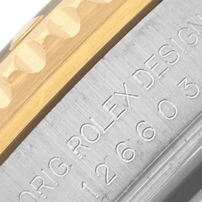 The image shows a close-up of the Rolex Sea-Dweller 126603 Men's Steel and Gold (two tone) Black Dial 126603 Men's Steel and Gold (two tone) Black Dial's case side, highlighting engraved text and part of the bezel.