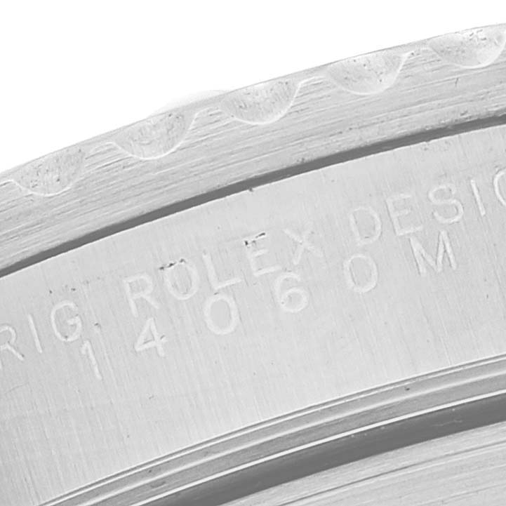 The image shows a close-up of the edge and engraving on the case back of a Rolex Submariner 14060M Men's Stainless Steel Black Dial 14060M Men's Stainless Steel Black Dial watch.