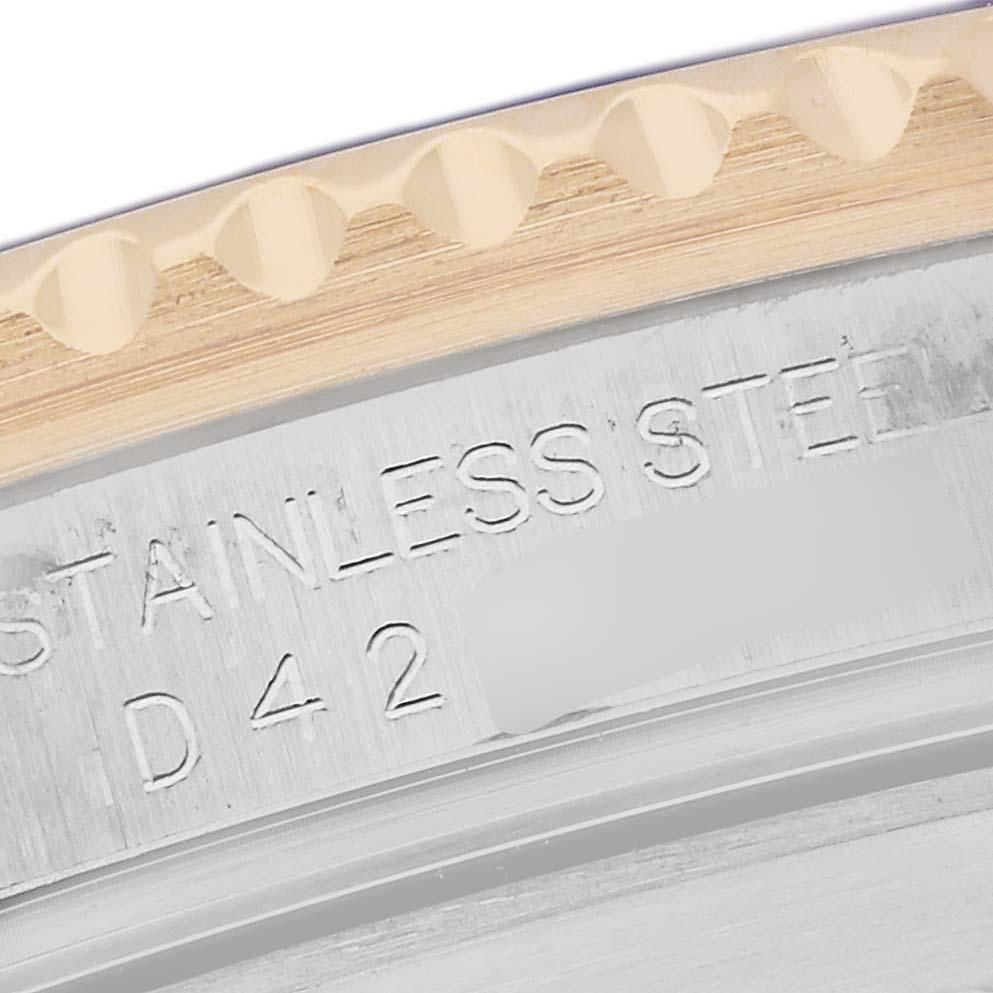 The image shows a close-up of the Rolex Submariner 16613 Men's Steel and Gold (two tone) Blue Dial 16613 Men's Steel and Gold (two tone) Blue Dial's stainless steel case edge and part of the engraved bezel.