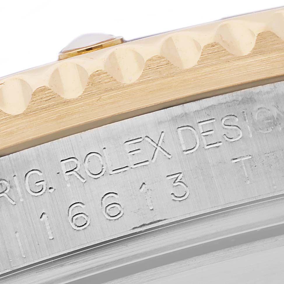 The image shows a close-up of the Rolex Submariner 16613 Men's Steel and Gold (two tone) Blue Dial 16613 Men's Steel and Gold (two tone) Blue Dial's engraved case with part of the bezel in view.