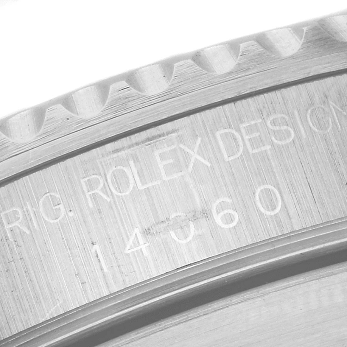 This image shows a close-up of the engraving on the inner bezel of a Rolex Submariner 14060 Men
s Stainless Steel Black Dial 14060 Men
s Stainless Steel Black Dial watch.