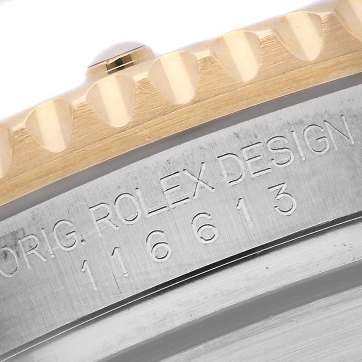 The image shows a close-up angle of the bezel and the engraved edge of a Rolex Submariner 116613 Men
s Steel and Gold (two tone) Blue Dial 116613 Men
s Steel and Gold (two tone) Blue Dial model watch.