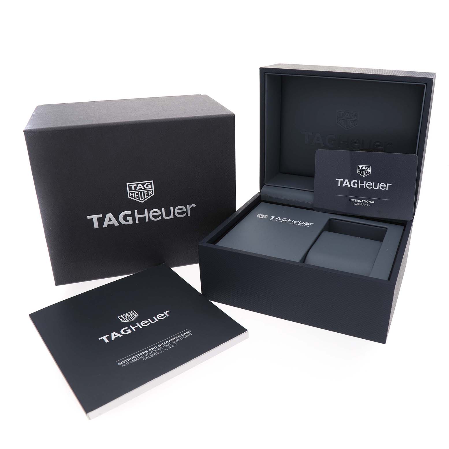 The image shows the packaging for a Tag Heuer Aquaracer WAY201A Men's Stainless Steel Black Dial, including a box, warranty card, and instruction booklet.