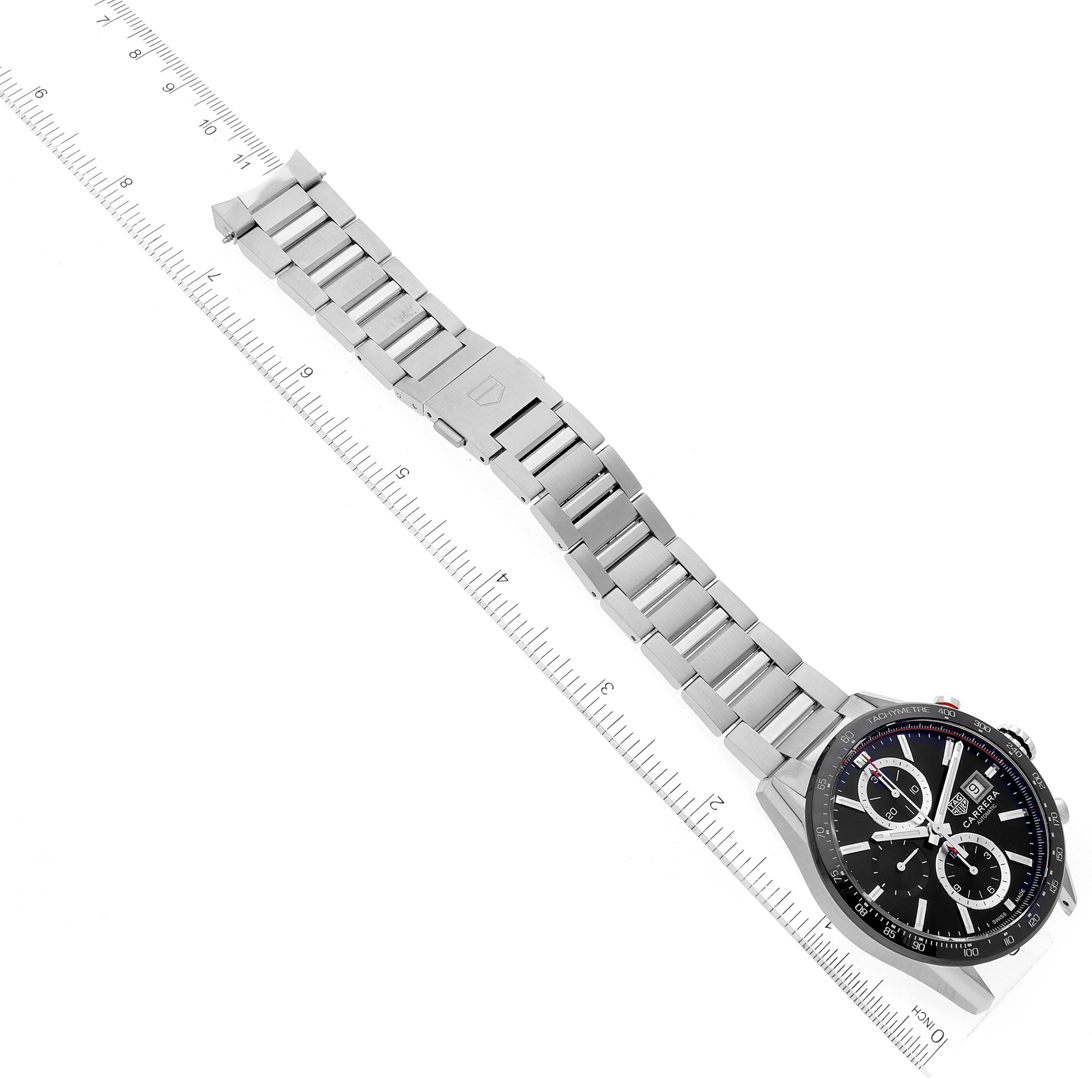 The image shows a top-down view of the Tag Heuer Carrera CBM2110 Men's Stainless Steel Black Dial CBM2110 Men's Stainless Steel Black Dial watch, including the watch face and metal bracelet with a ruler for scale.