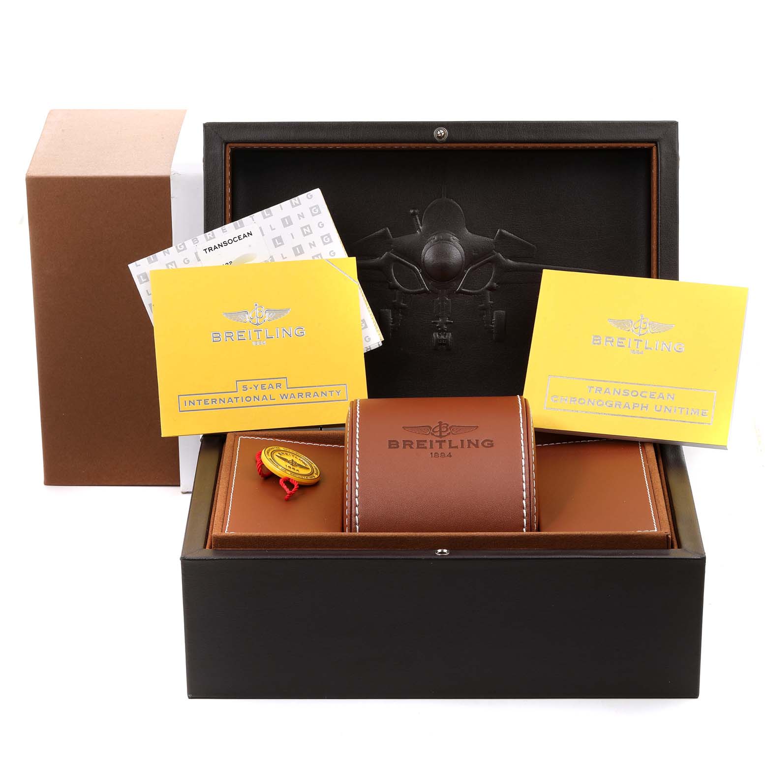 The image shows a Breitling Transocean RB0510U4-BB63BKLD Men's Rose Gold White Dial RB0510U4-BB63BKLD Men's Rose Gold White Dial watch box with warranty cards, a medallion, and a leather case.