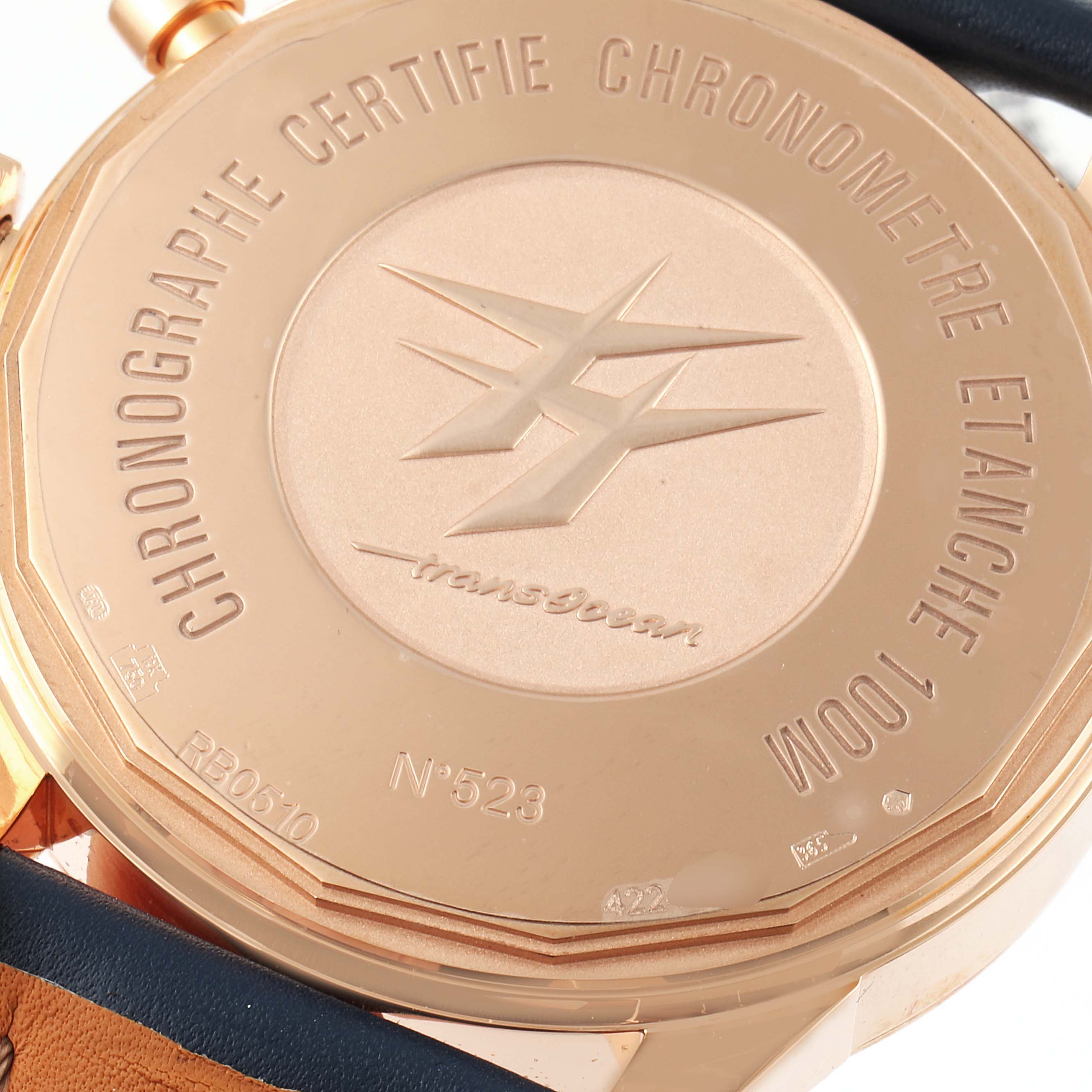 The image shows the back case of a Breitling Transocean RB0510U4-BB63BKLD Men's Rose Gold White Dial RB0510U4-BB63BKLD Men's Rose Gold White Dial watch, featuring engravings and markings.