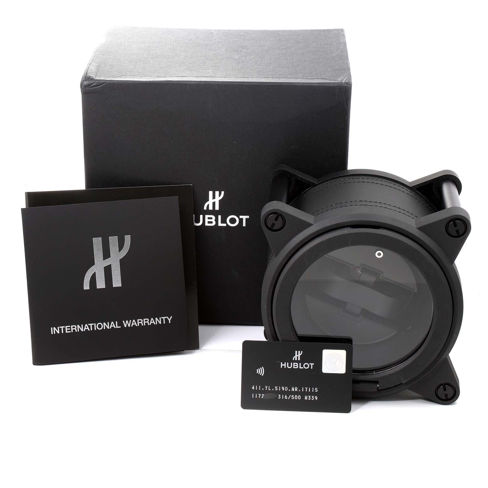 The image shows the packaging, warranty card, and case for the Hublot Big Bang Unico 411.YL.5190.NR.ITI16 Men's Titanium Transparent Dial 411.YL.5190.NR.ITI16 Men's Titanium Transparent Dial model watch.