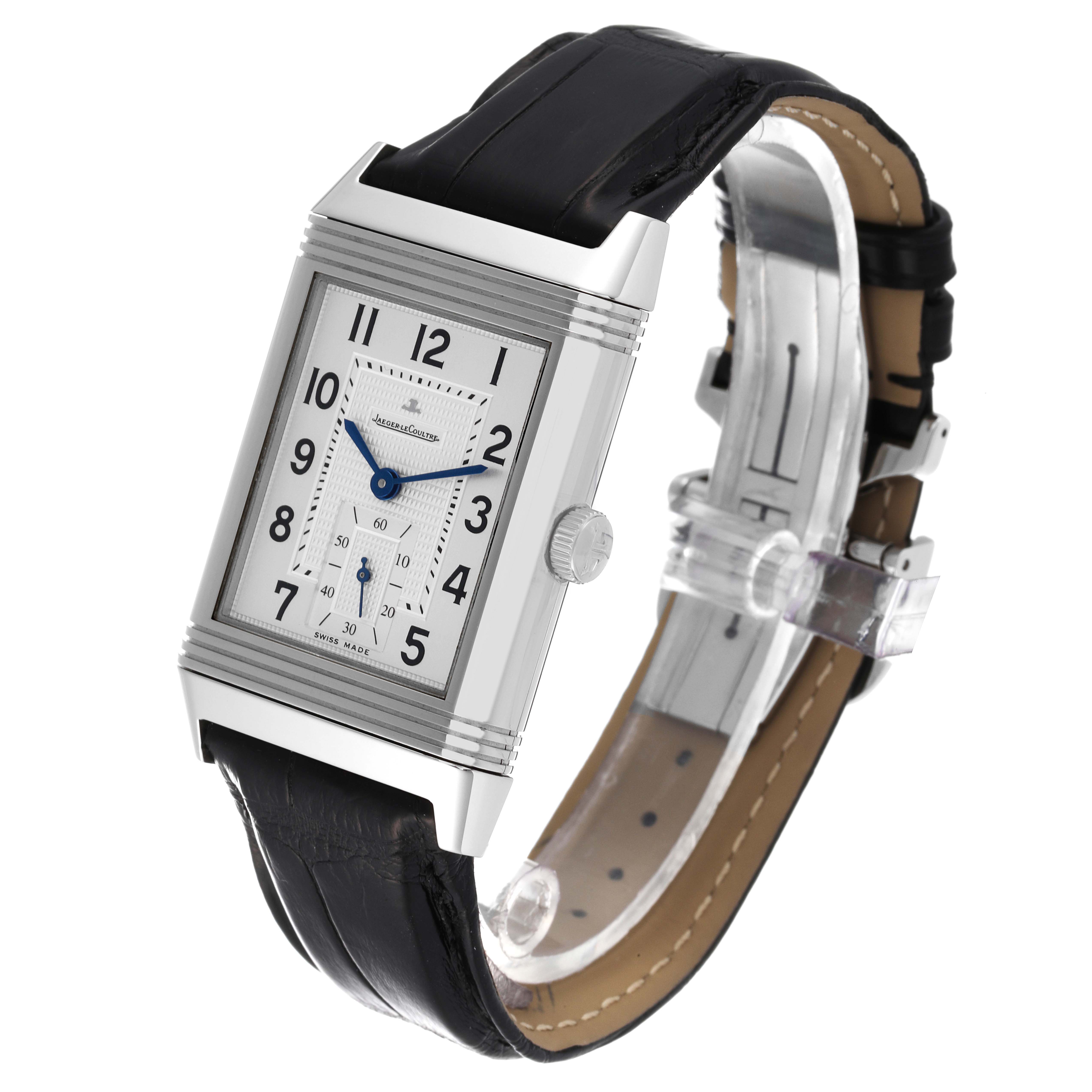The image shows a front angle of the Jaeger-LeCoultre Reverso watch, highlighting its rectangular face, silver case, black leather strap, and blue hands.