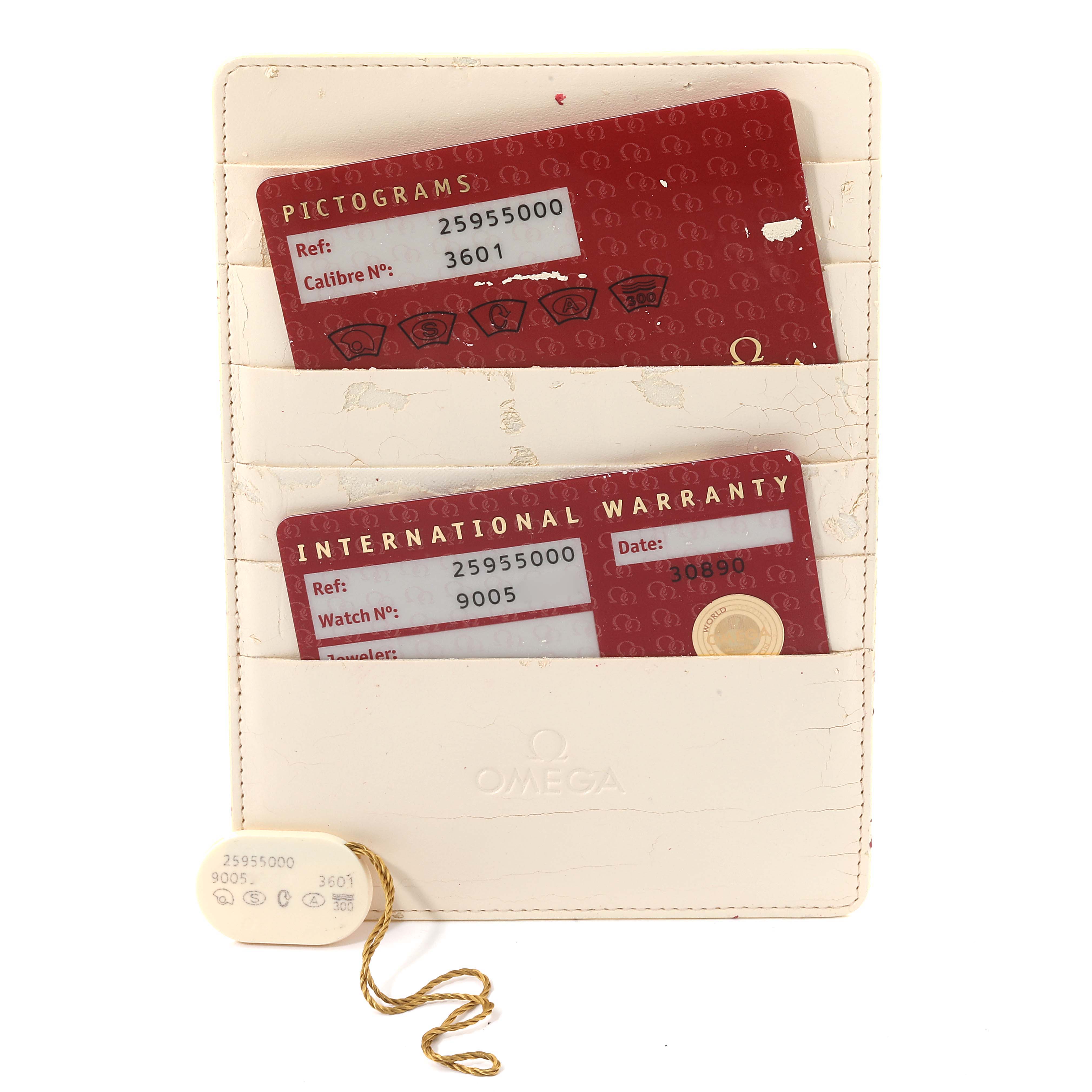 The image shows warranty and pictogram cards for an Omega Seamaster 2595.50.00 Men's Stainless Steel Black Dial 2595.50.00 Men's Stainless Steel Black Dial watch, along with a white cardholder and a tag.