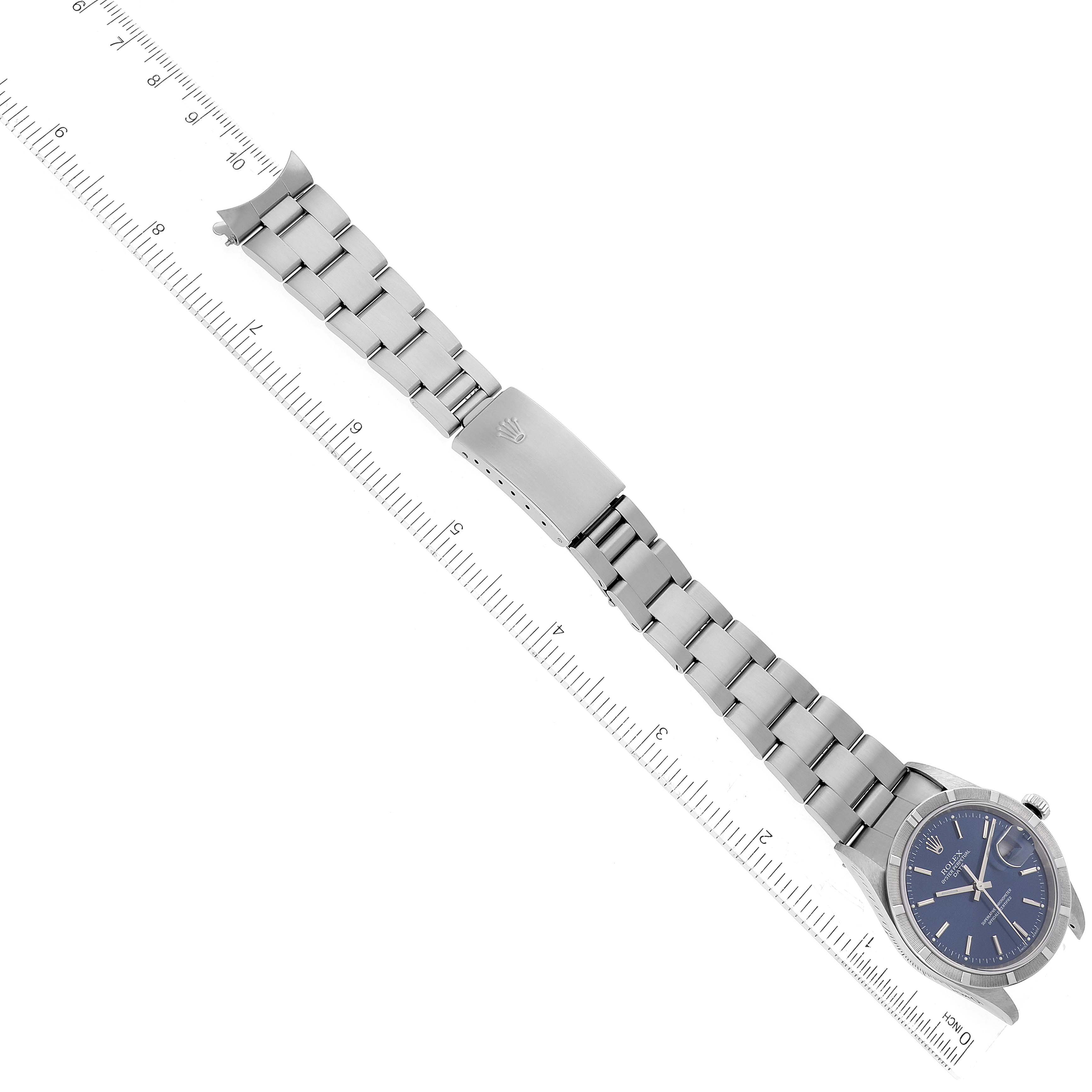 The image shows a Rolex Date 15210 Men's Stainless Steel Blue Dial 15210 Men's Stainless Steel Blue Dial model watch laid flat, displaying its face, bracelet, and clasp with a ruler for scale.