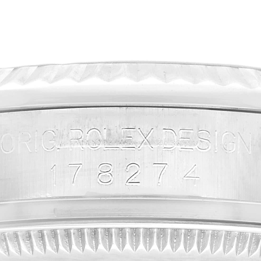 This image shows a close-up of the etched serial number and "Rolex Design" inscription on the case of a Rolex Mid-Size 178274 Women
s Stainless Steel Silver Dial 178274 Women
s Stainless Steel Silver Dial model watch.