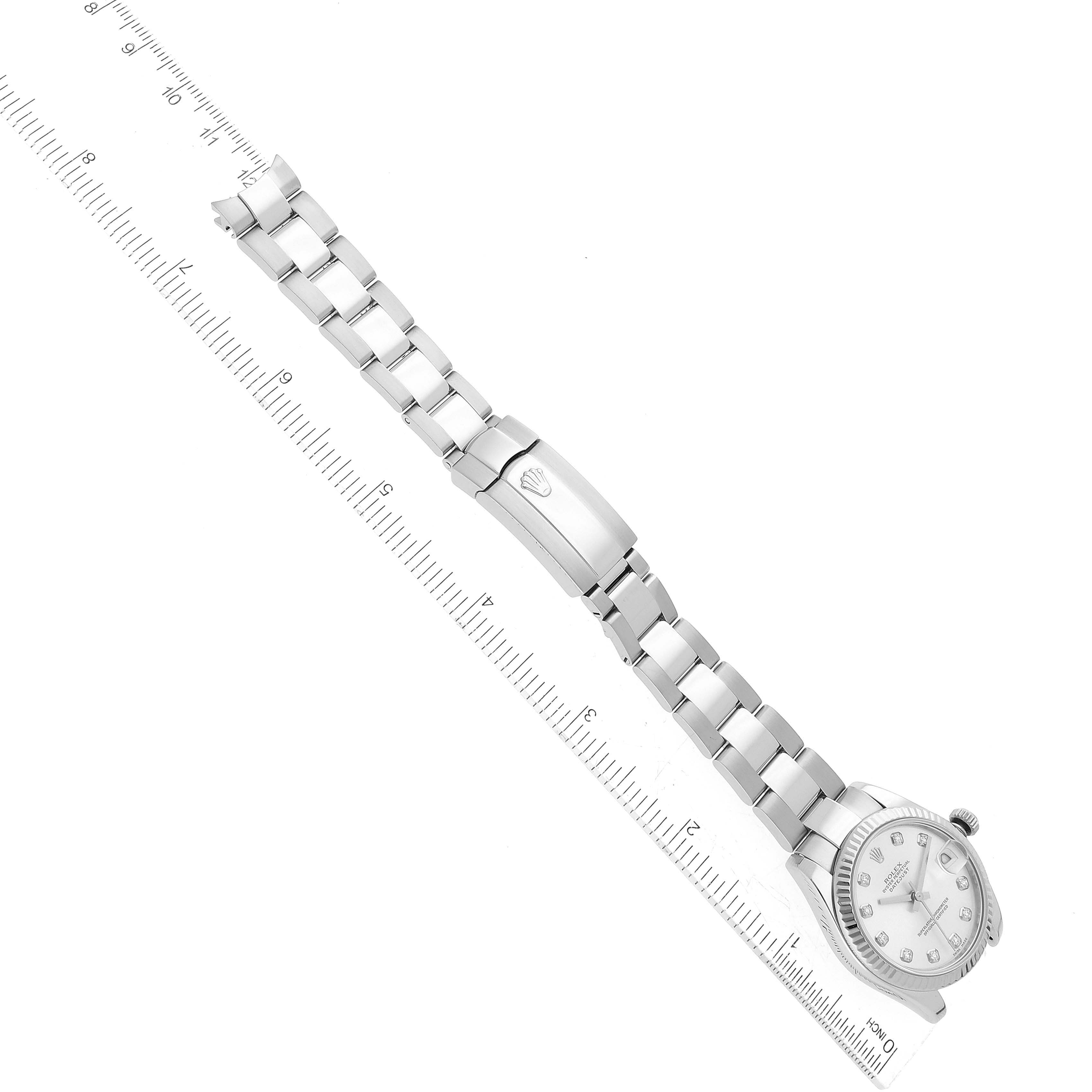 The image shows a top-down view of a Mid-Size Rolex watch showing the dial, bracelet, clasp, and surrounding area with a ruler for size reference.