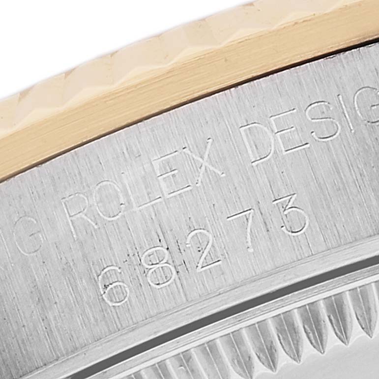 The image shows a close-up of the case back and edge of the bezel of a Rolex Mid-Size 68273 Women's Steel and Gold (two tone) Black Dial 68273 Women's Steel and Gold (two tone) Black Dial model 68273 watch.