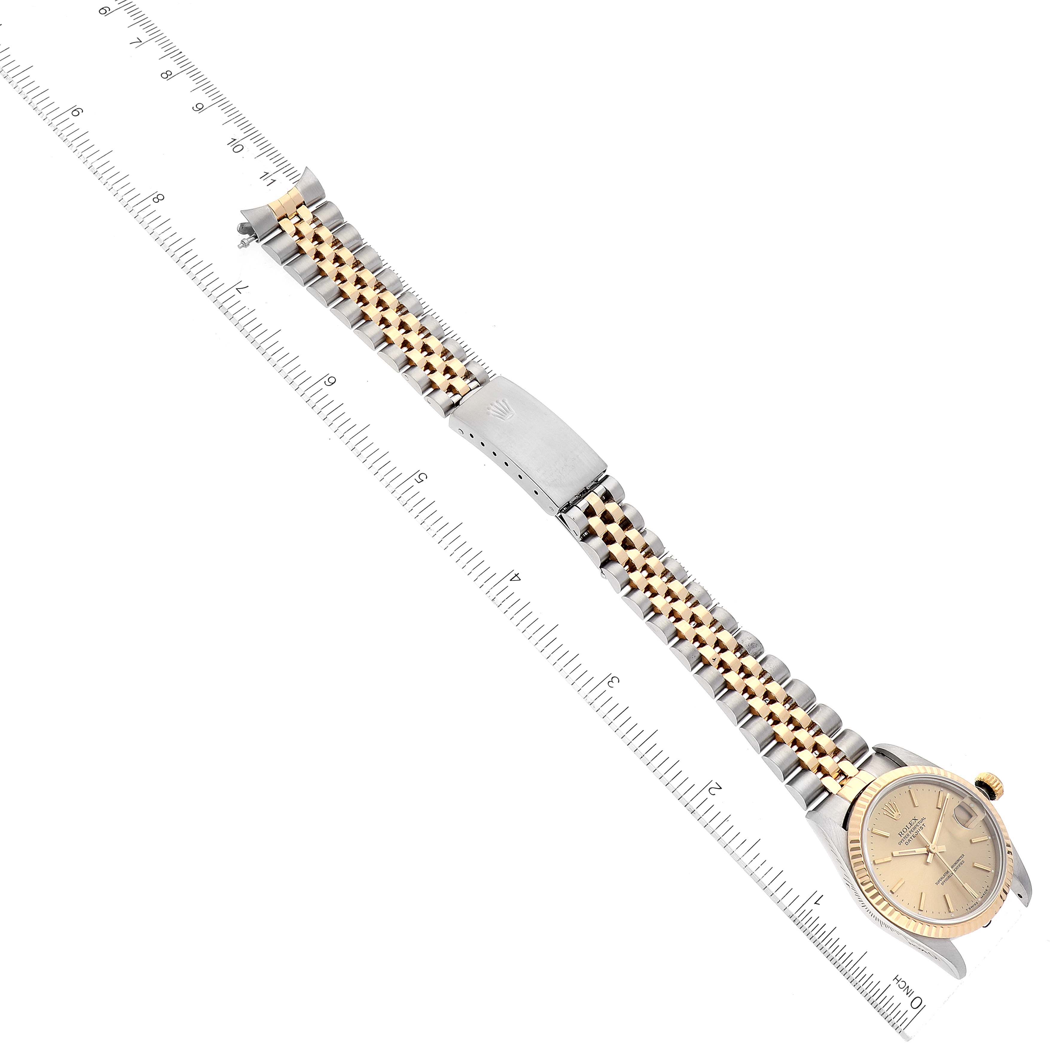 This image shows a Mid-Size Rolex watch laid flat with its face, bezel, and bracelet visible, measured alongside a ruler.