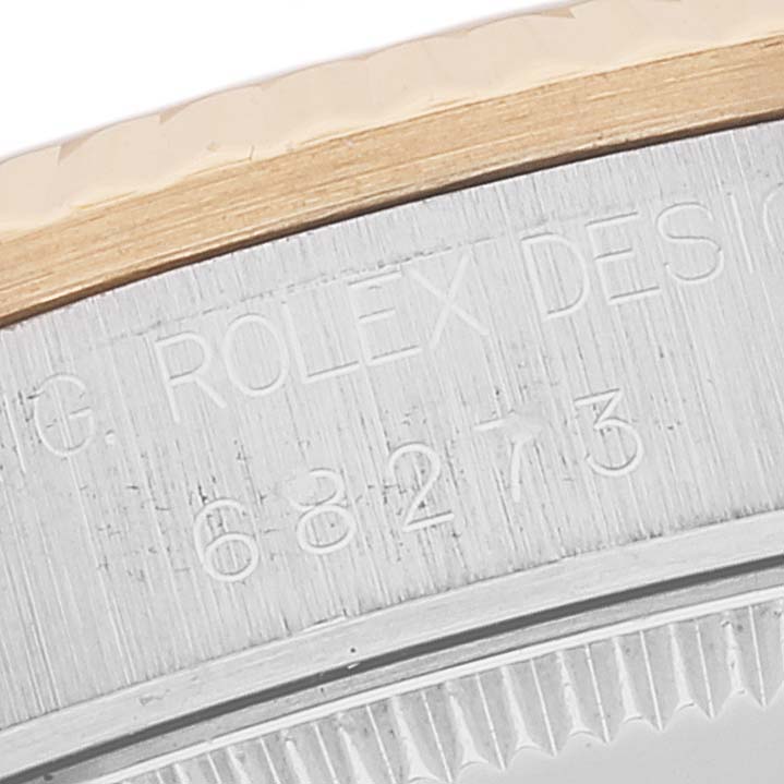 A close-up view of a Rolex Mid-Size 68273 Women's Steel and Gold (two tone) Champagne Dial 68273 Women's Steel and Gold (two tone) Champagne Dial model showing part of the bezel and engraved serial numbers.