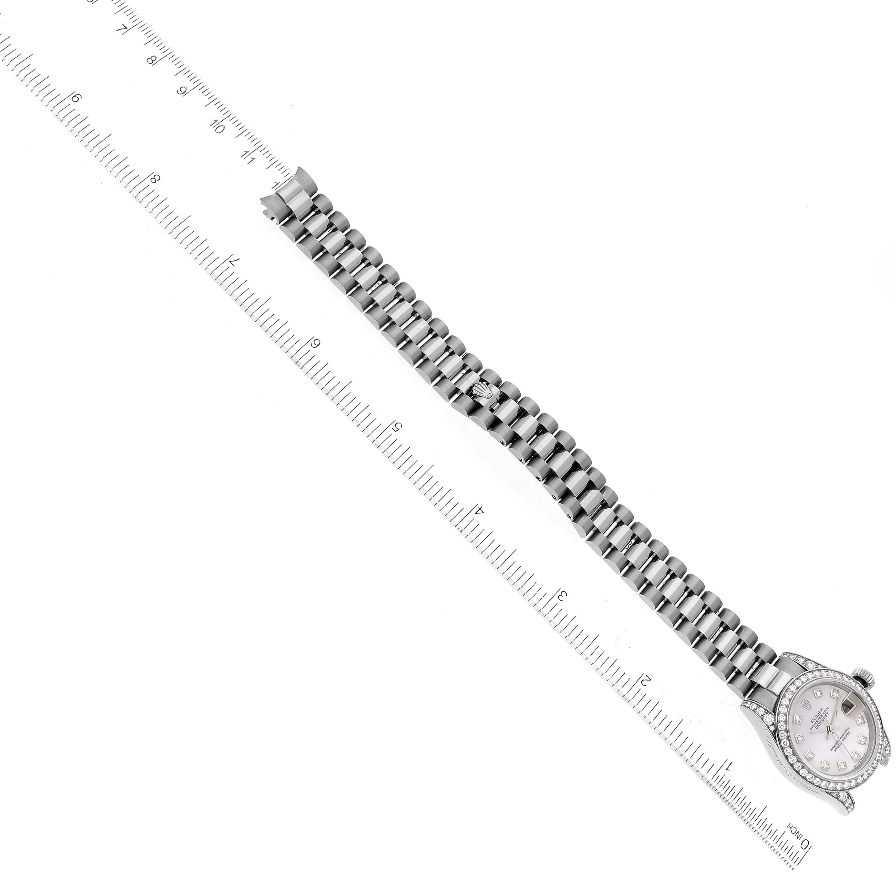 The image shows an overhead view of a Rolex President 179159 Women's White Gold Mother of Pearl Dial 179159 Women's White Gold Mother of Pearl Dial model watch alongside a ruler, displaying the full strap and dial.