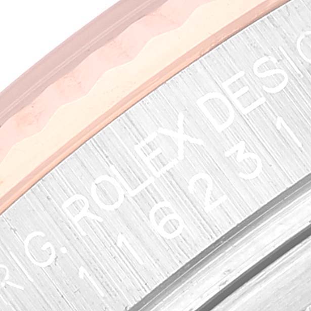 This close-up angle of the Rolex Datejust 116231 Men's Steel and Gold (two tone) White Dial 116231 Men's Steel and Gold (two tone) White Dial watch shows part of the bezel and engraved serial number.