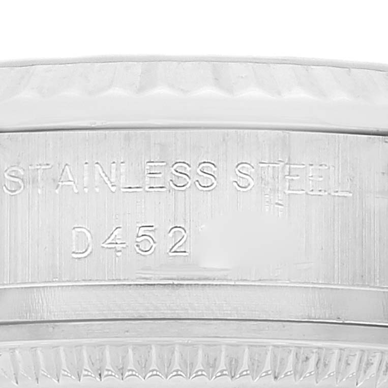 The image shows a close-up of the side of a Rolex Datejust 179174 Women's Stainless Steel Blue Dial 179174 Women's Stainless Steel Blue Dial watch, highlighting the "Stainless Steel" engraving and partial serial number.