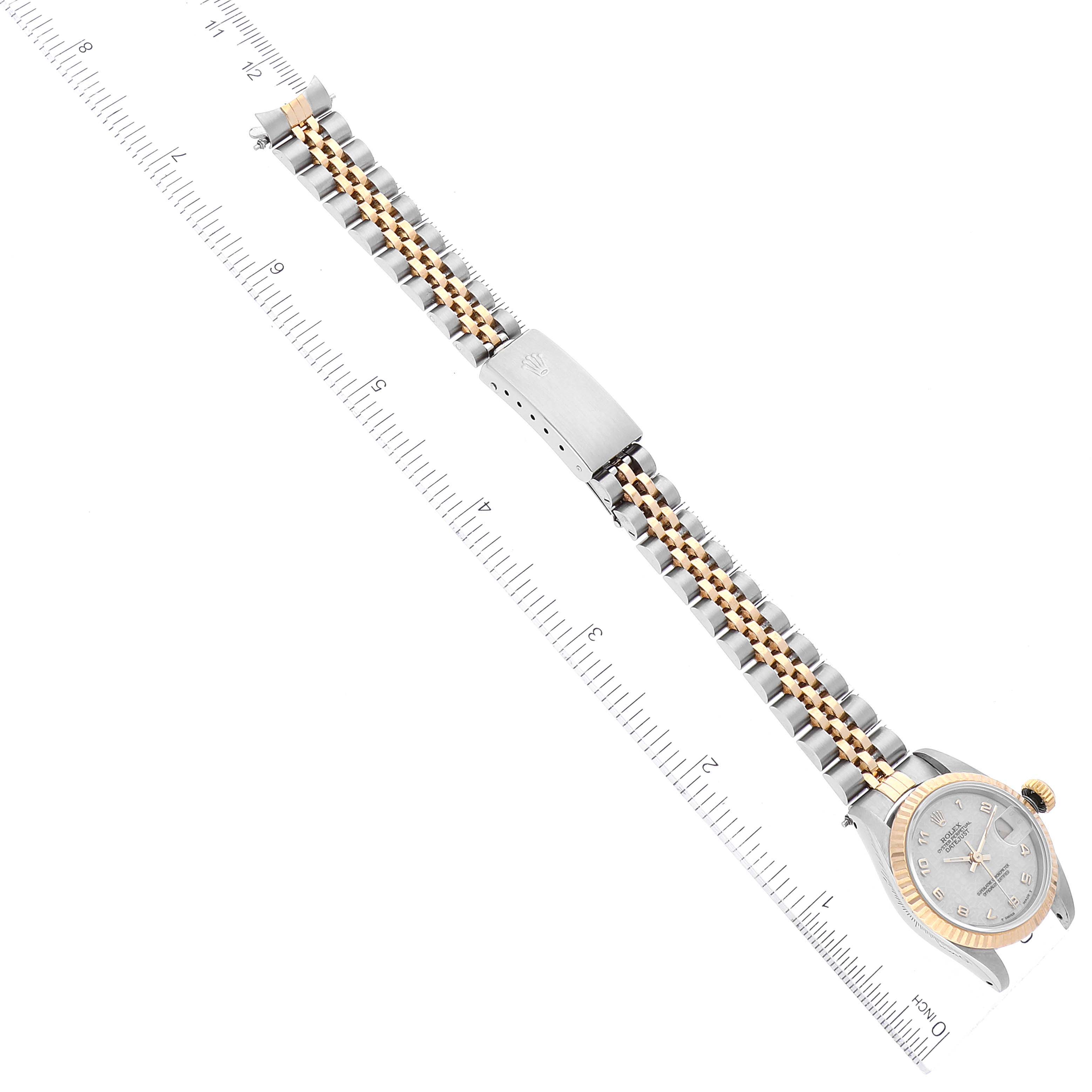 The Rolex Datejust 69173 Women's Steel and Gold (two tone) Beige Dial 69173 Women's Steel and Gold (two tone) Beige Dial watch is shown lying flat with its band and case visible, alongside a ruler for scale.