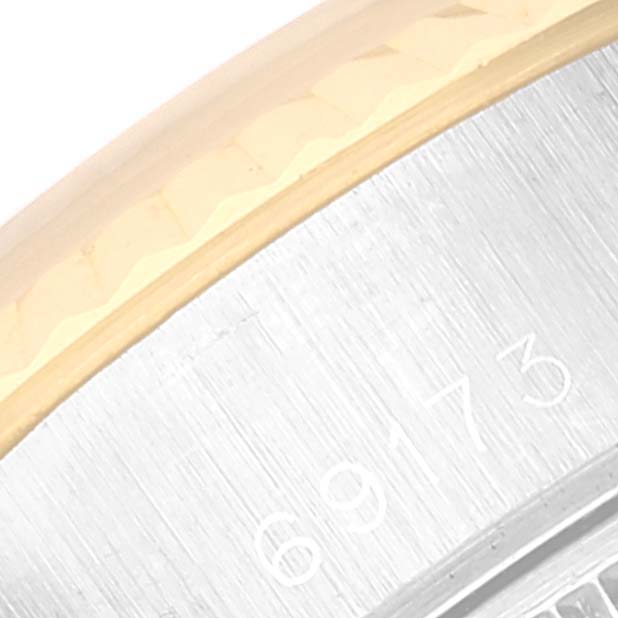 This close-up image shows the edge of the bezel and the engraved case back of a Rolex Datejust 69173 Women's Steel and Gold (two tone) Beige Dial 69173 Women's Steel and Gold (two tone) Beige Dial model.