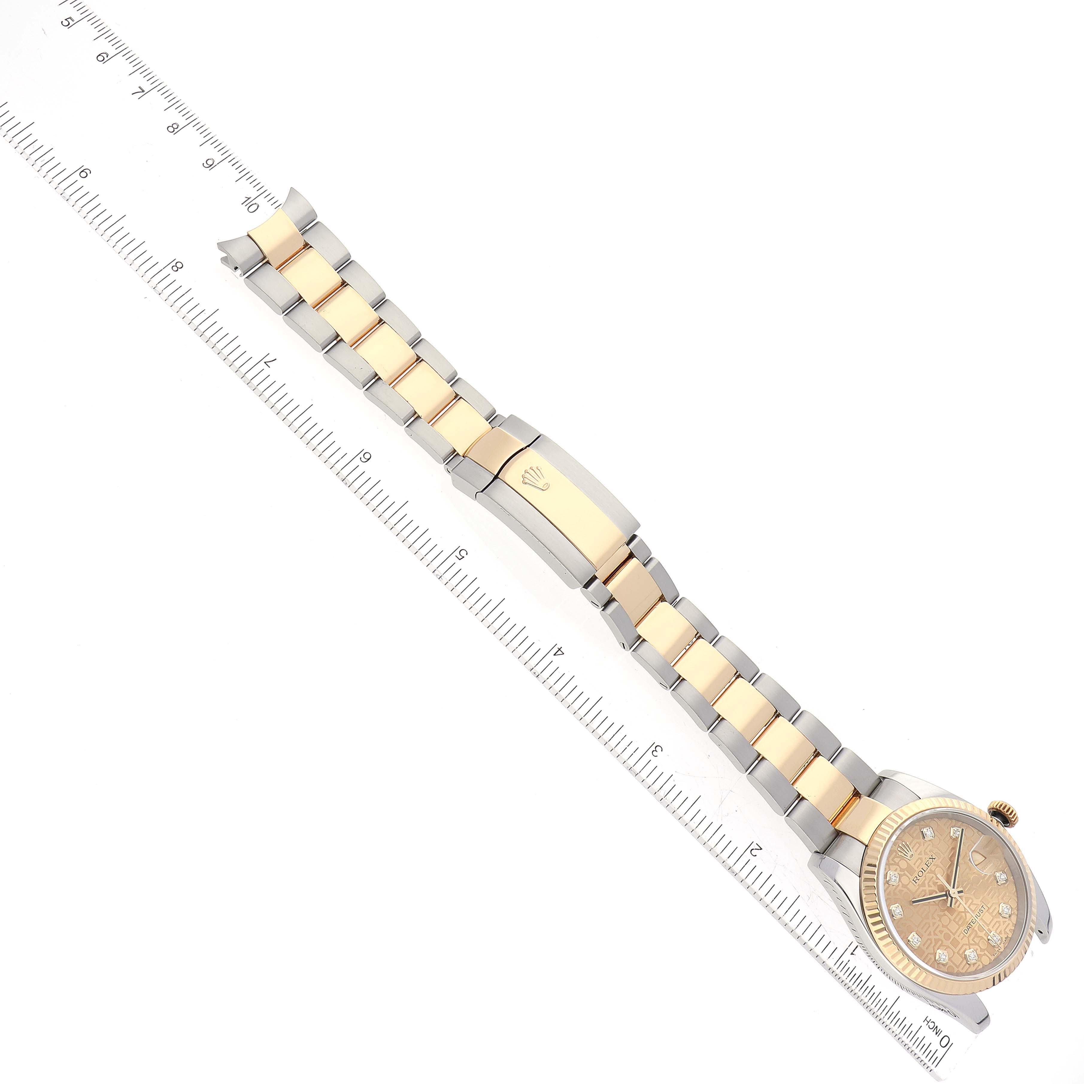 The Rolex Datejust 116233 Men's Steel and Gold (two tone) Champagne Dial 116233 Men's Steel and Gold (two tone) Champagne Dial watch is shown from a top-down angle, displaying the face, bezel, and entire bracelet next to a ruler for scale.
