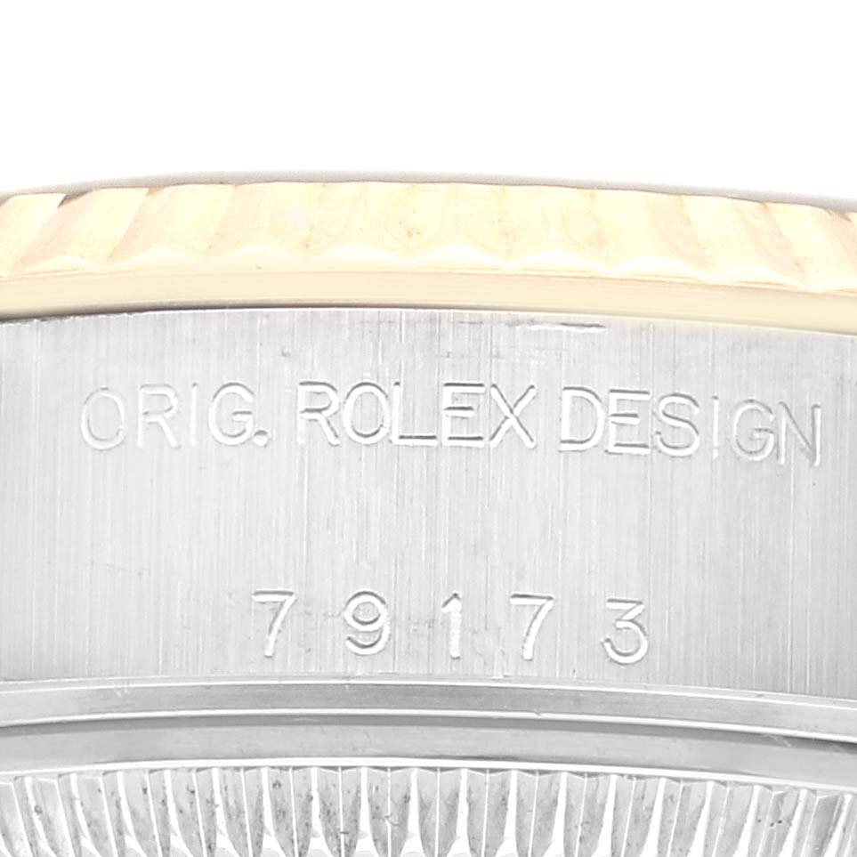 This image shows an engraving of "ORIG. ROLEX DESIGN" and "79173" on the side of the bezel of a Rolex Datejust 79173G Women's Steel and Gold (two tone) Black Dial 79173G Women's Steel and Gold (two tone) Black Dial watch.